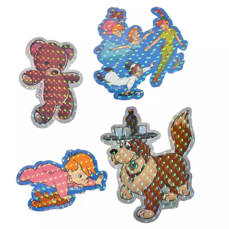 Four holographic stickers of cartoon characters including a teddy bear, children flying, a child crawling, and a dog wearing a hat.
