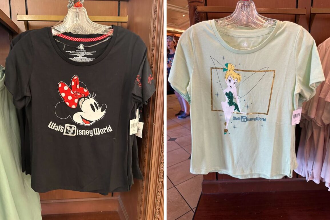 Two T-shirts on hangers displayed on a wooden rack: one black with a Minnie Mouse graphic and "Walt Disney World" text, and one light green with Tinker Bell graphic also featuring "Walt Disney World" text.