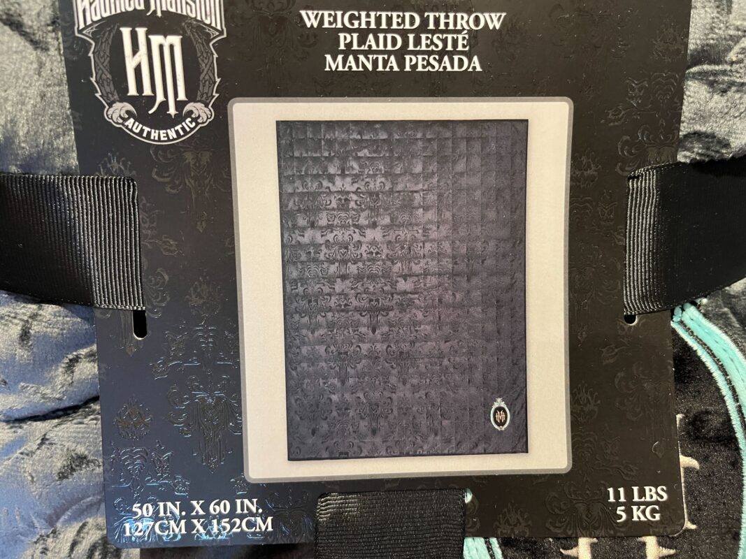 A weighted throw blanket with Haunted Mansion branding. The blanket measures 50 inches by 60 inches and weighs 11 pounds (5 kg).