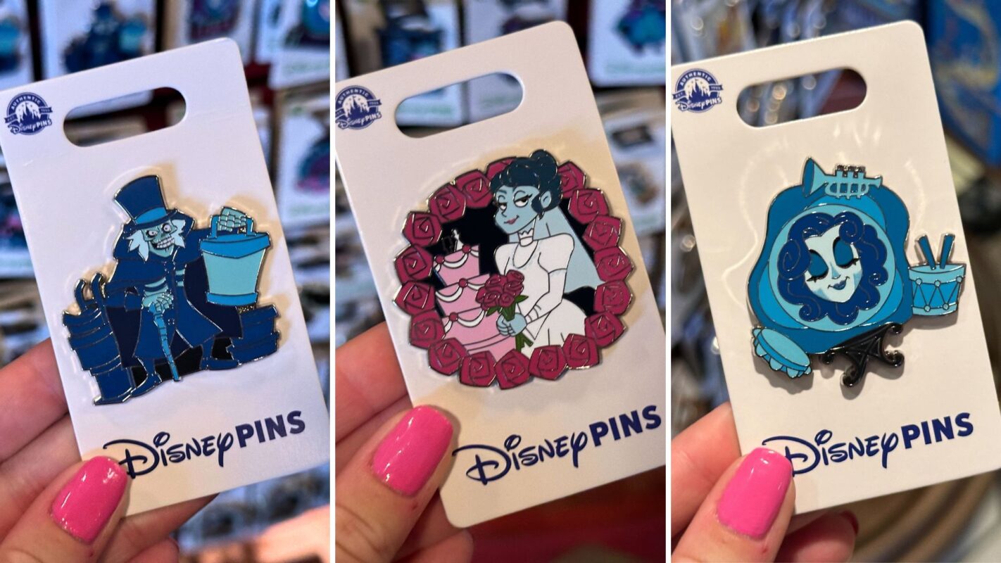 Three Disney pins are shown in someone's hand. The pins feature cartoon-style characters in various designs, attached to white backing cards labeled "Disney Pins.
