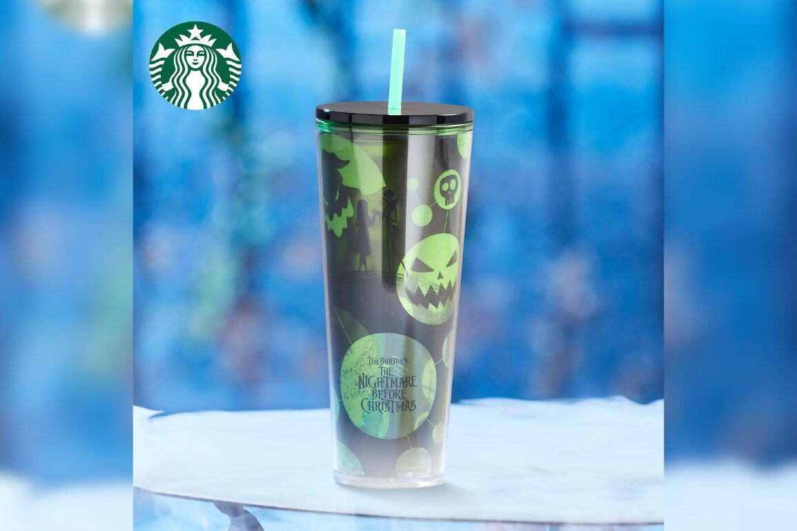 A Disney Store exclusive, this Starbucks tumbler showcases designs from "The Nightmare Before Christmas" in dark shades with green accents, a green lid, and a green straw. The Starbucks logo is prominently displayed in the top left corner.