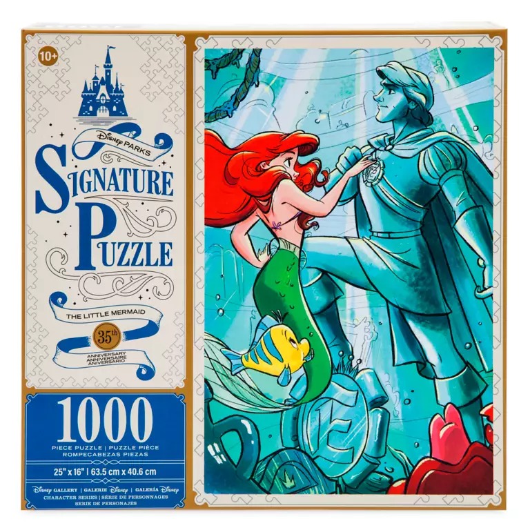 A 1000-piece Disney Parks Signature Puzzle featuring "The Little Mermaid" characters Ariel and Prince Eric, alongside Flounder and Sebastian. The box includes a castle illustration and prominently states "Signature Puzzle.