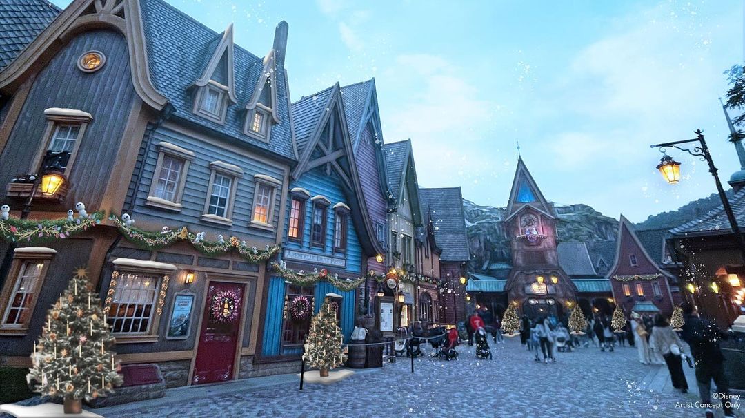 A charming street adorned with Christmas lights and decorations seems as if it were crafted by an Auto Draft. People stroll along the cobblestone path past picturesque buildings under a blue sky.