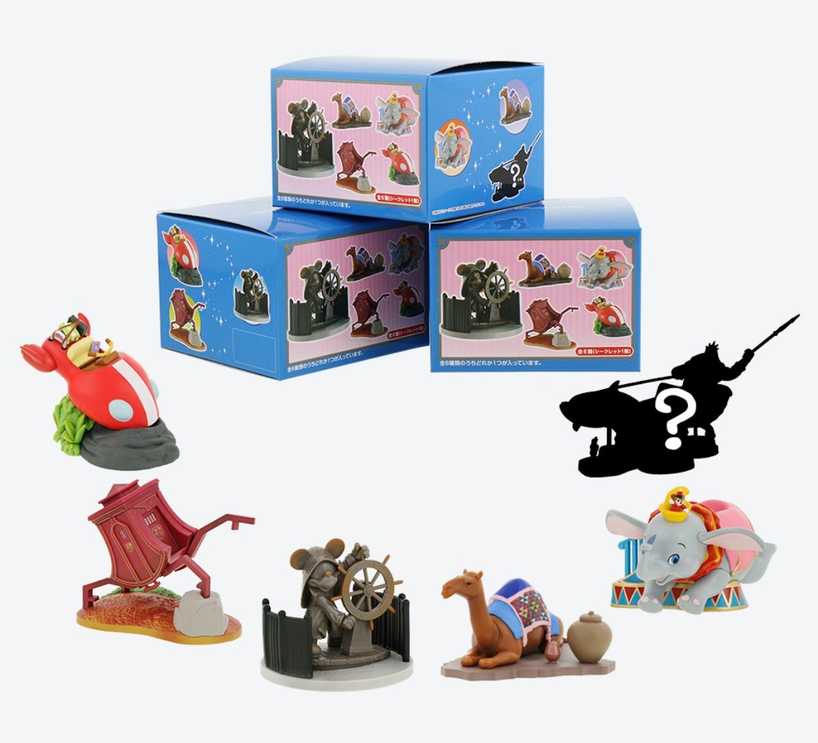 A set of Disney-themed collectible figurines displayed with their corresponding boxes, featuring characters like Dumbo and a camel. One figure is shown as a silhouette with a question mark.