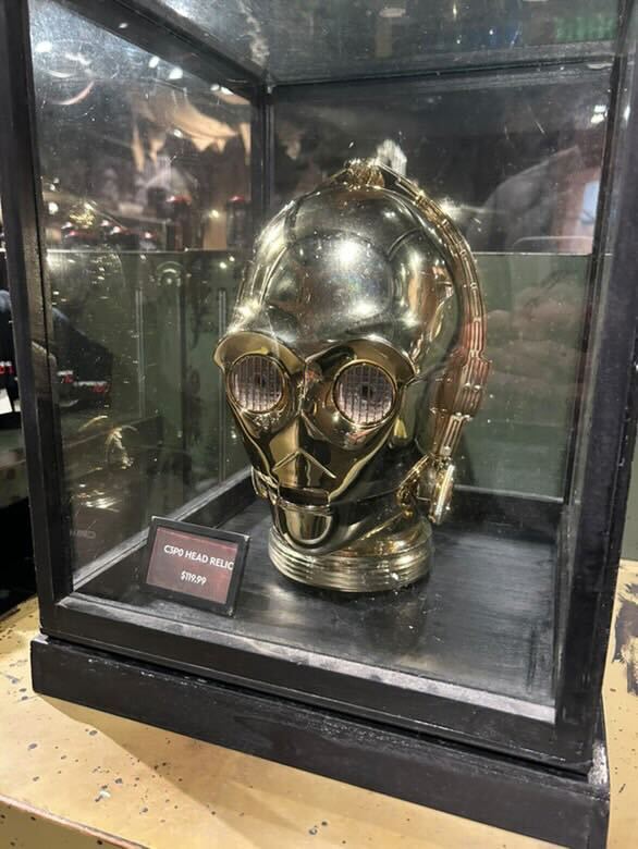 Gold-colored robotic head displayed in a glass case with a price tag of $699.99.
