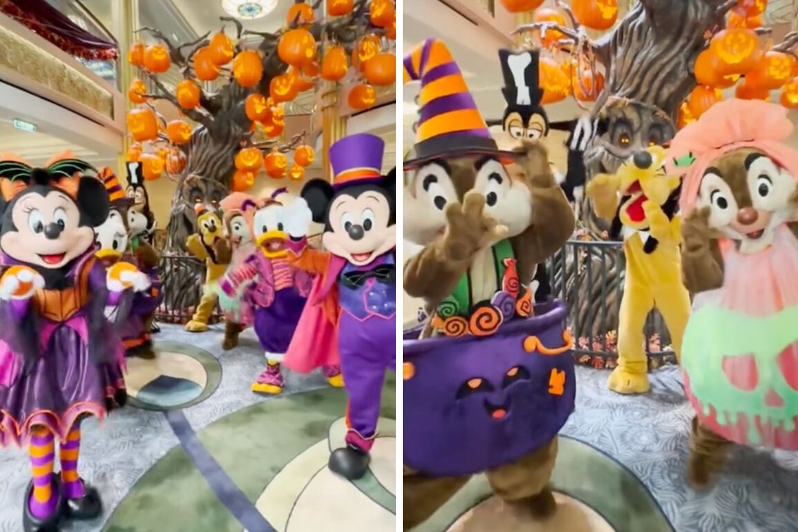 Characters in Halloween costumes, including mice, ducks, and chipmunks, stand in a festive setting reminiscent of Halloween on the High Seas. Mickey leads the celebration amid orange pumpkin decorations and a spiral tree in the background.