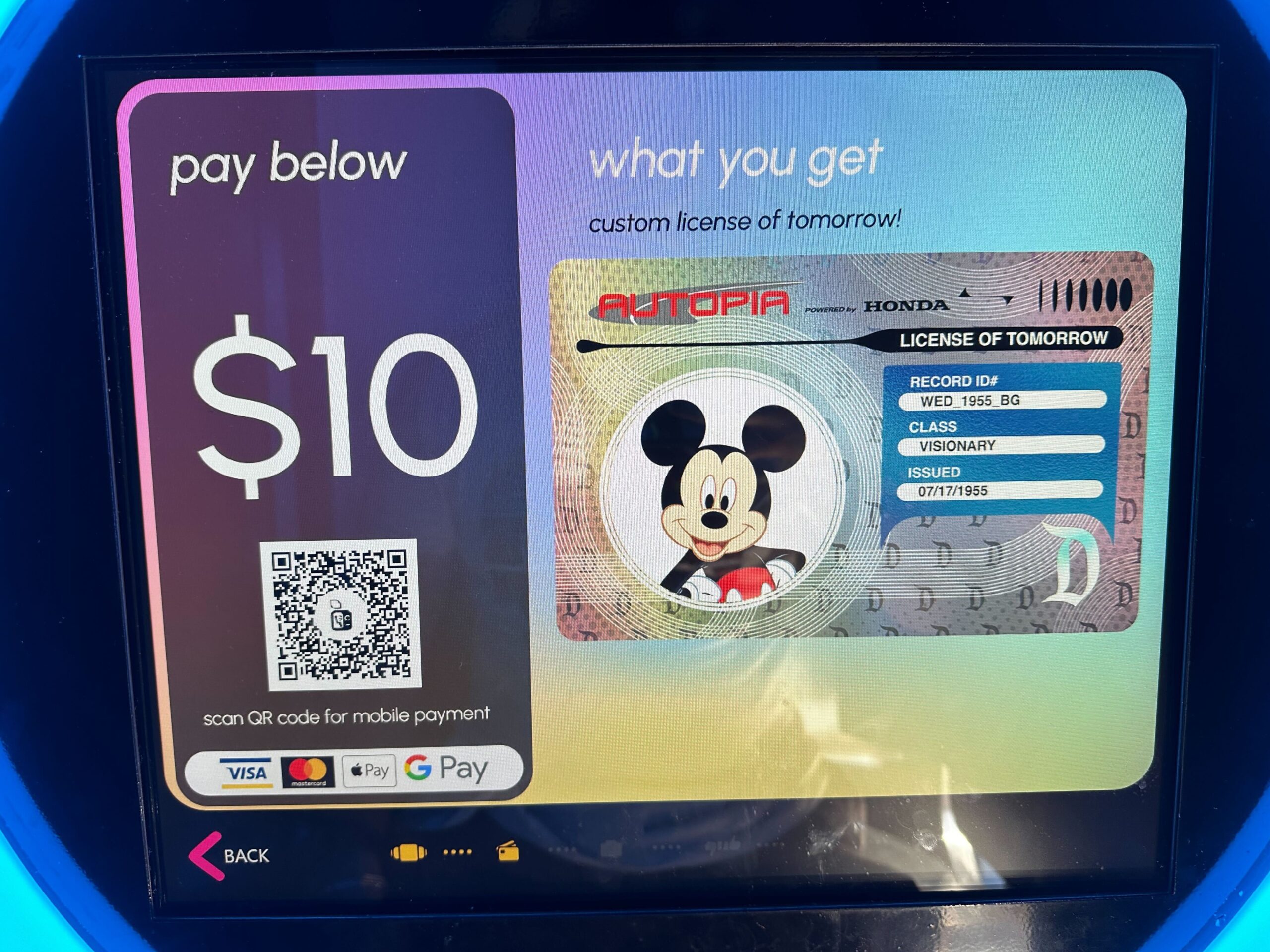 Digital screen showing a $10 payment for a custom "License of Tomorrow" card featuring a cartoon character. Payment options include QR code, Visa, Mastercard, and Apple Pay.