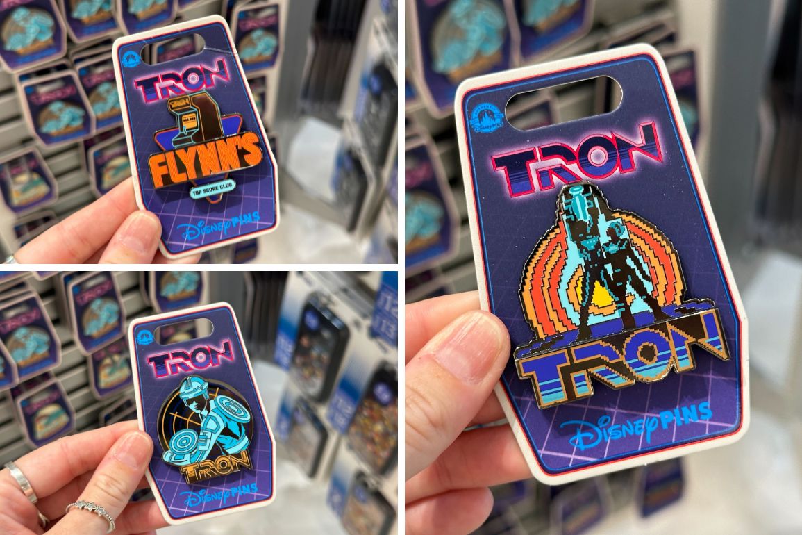 Hands holding various TRON-themed Disney pins with retro designs and vibrant colors, reminiscent of the Magic Kingdom's enchanting allure.