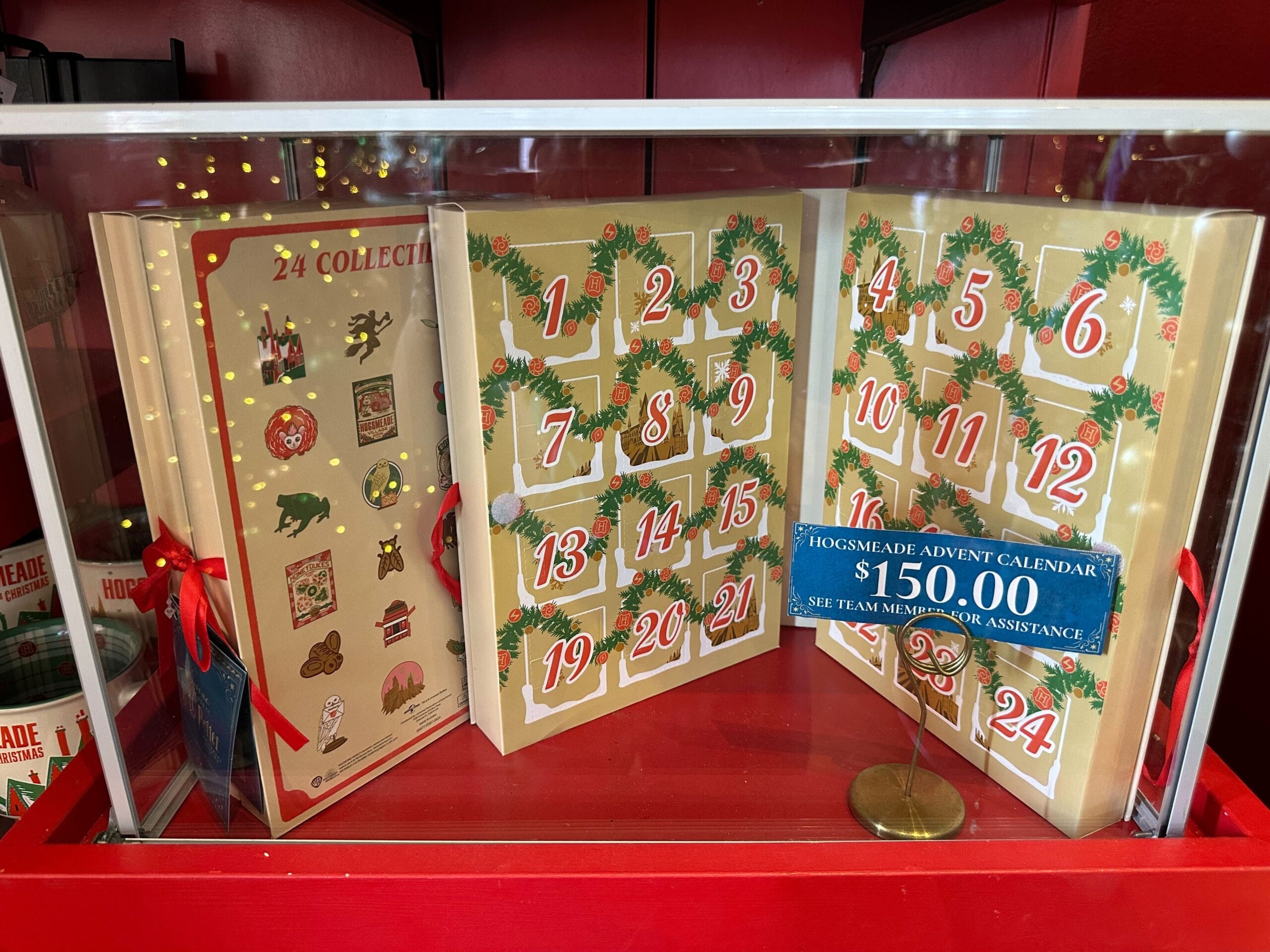 The enchanting Hogsmeade Advent Calendar, priced at $150.00, is elegantly displayed in a glass case. A team member is on hand for assistance. The enchanting Hogsmeade Advent Calendar, priced at $150.00, is elegantly displayed in a glass case. A team member is on hand for assistance.