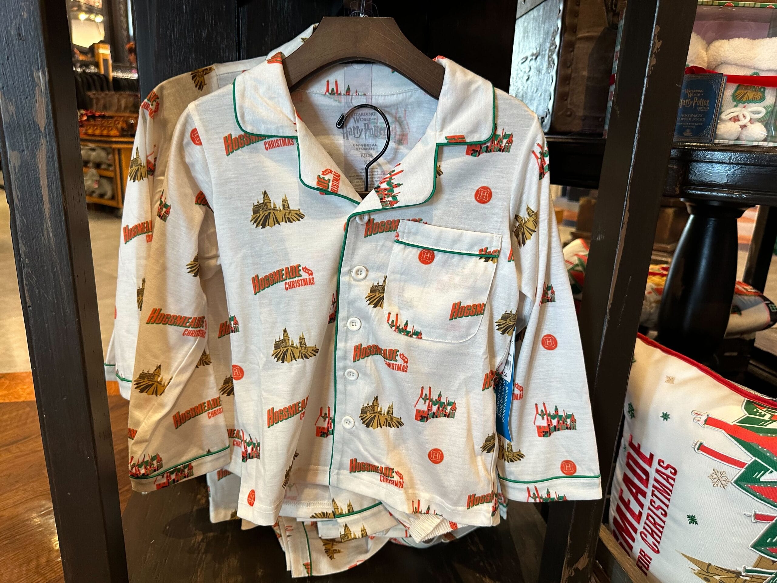 Children's pajamas with Christmas-themed graphics and the phrase "Home for Christmas" hang on a store display, reminiscent of a cozy evening in Hogsmeade. Children's pajamas with Christmas-themed graphics and the phrase "Home for Christmas" hang on a store display, reminiscent of a cozy evening in Hogsmeade.