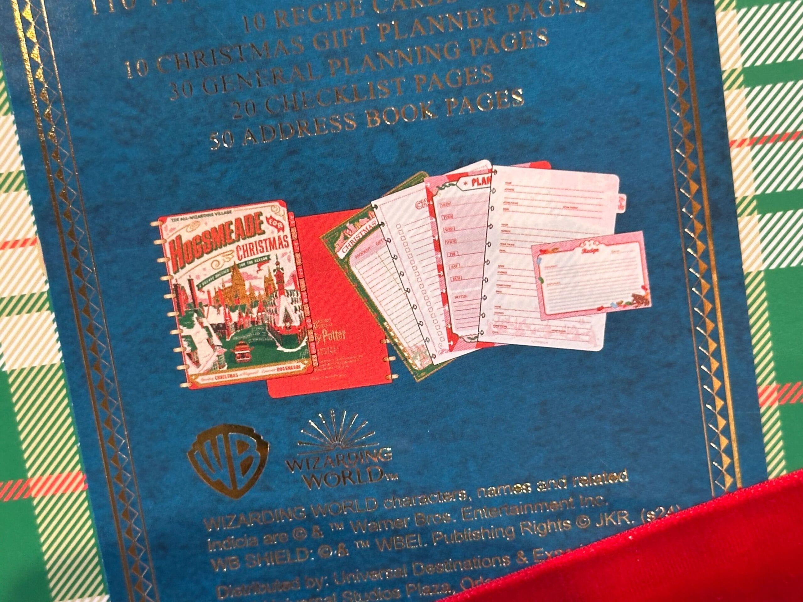 Close-up of a Wizarding World gift planner featuring whimsical illustrations and planning pages, set against a blue background reminiscent of a magical evening in Hogsmeade. Close-up of a Wizarding World gift planner featuring whimsical illustrations and planning pages, set against a blue background reminiscent of a magical evening in Hogsmeade.
