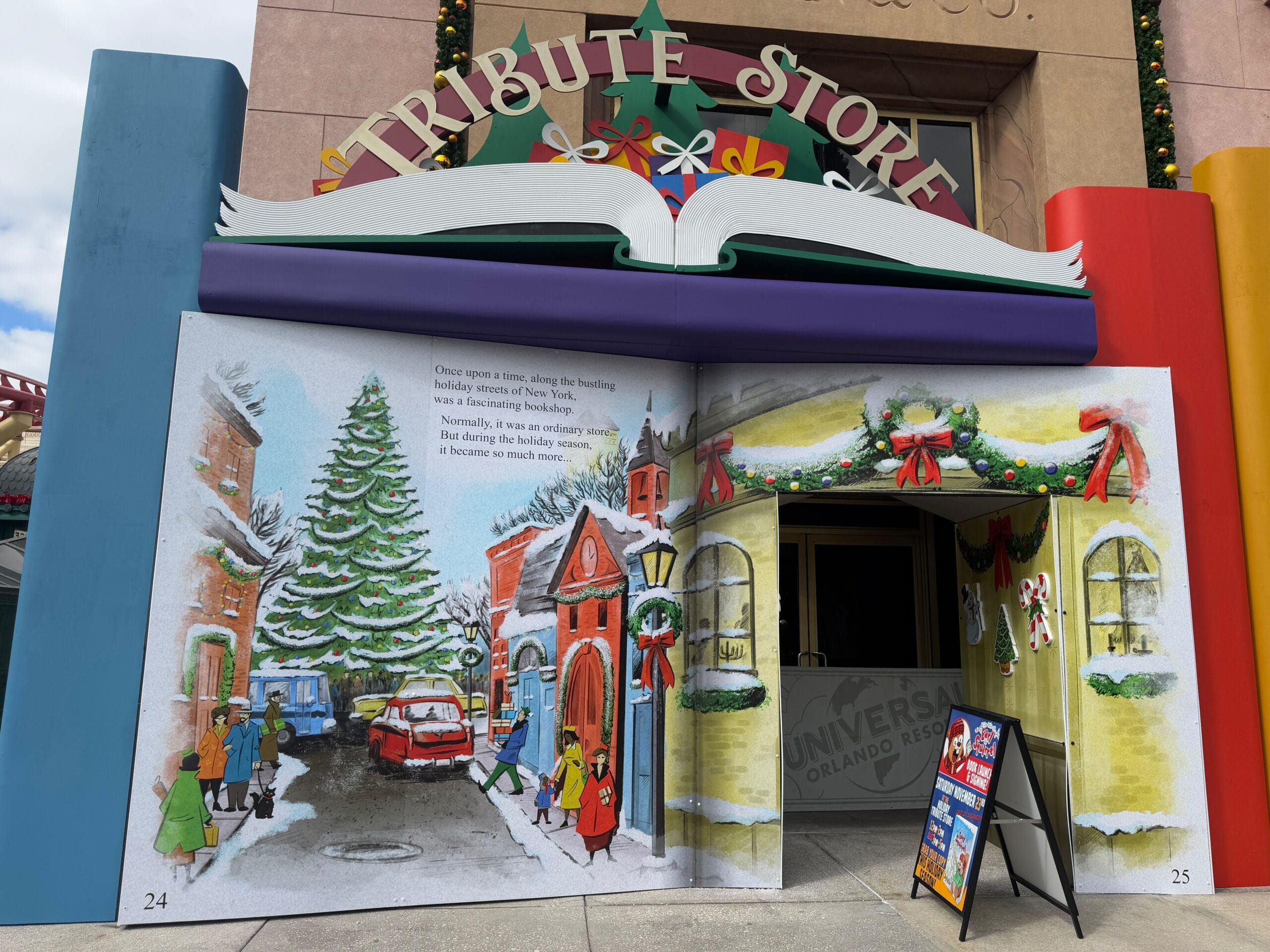 Tribute Store entrance resembling an open storybook with a holiday-themed illustration and decorations.