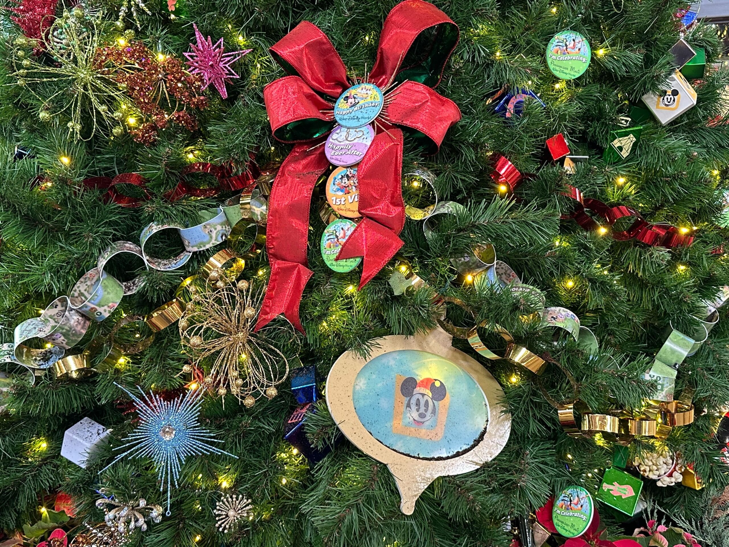 Christmas tree decorated with a red bow, colorful paper chains, ornaments, and various baubles.
