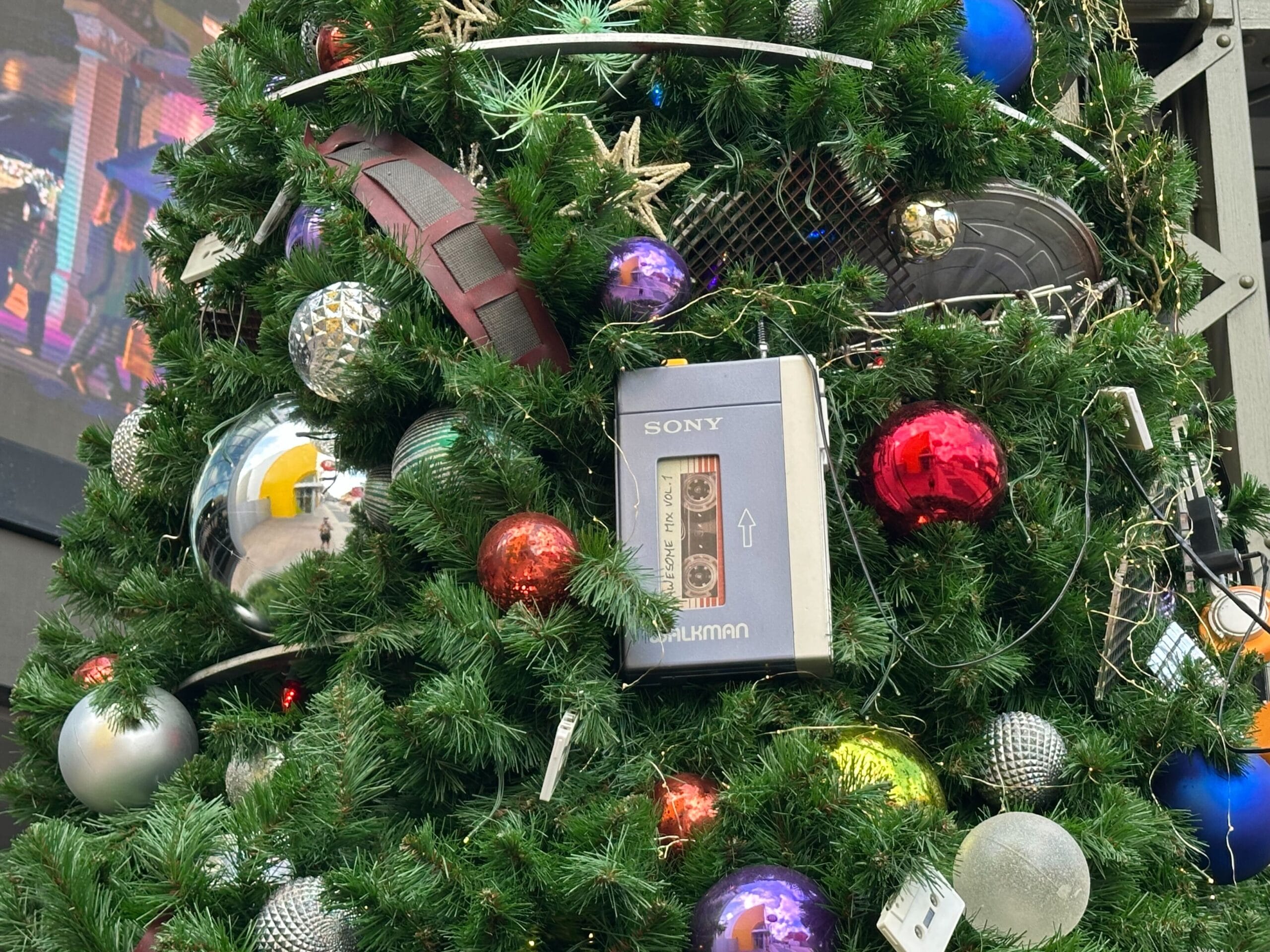 Christmas tree adorned with colorful ornaments and a large, decorative Sony Walkman among the branches.
