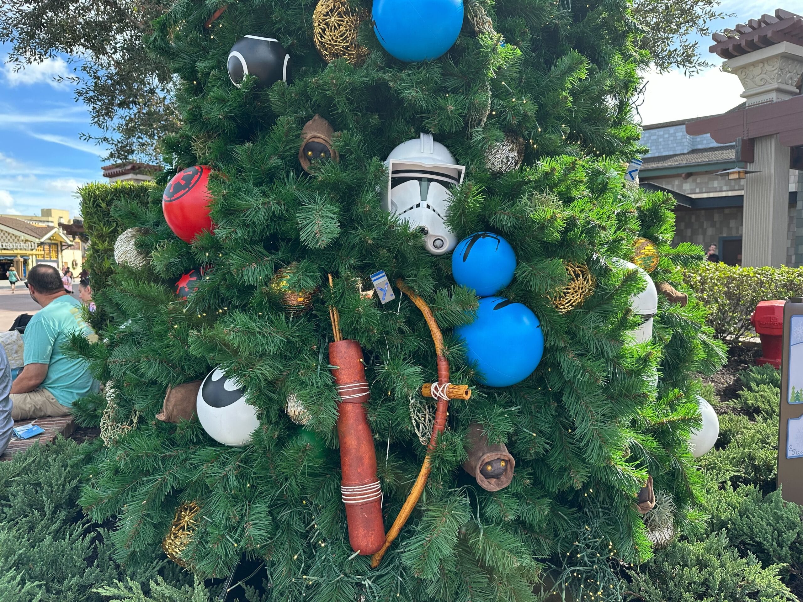 Christmas tree decorated with Star Wars-themed ornaments, including a stormtrooper helmet, colorful spherical ornaments, and a toy bow.