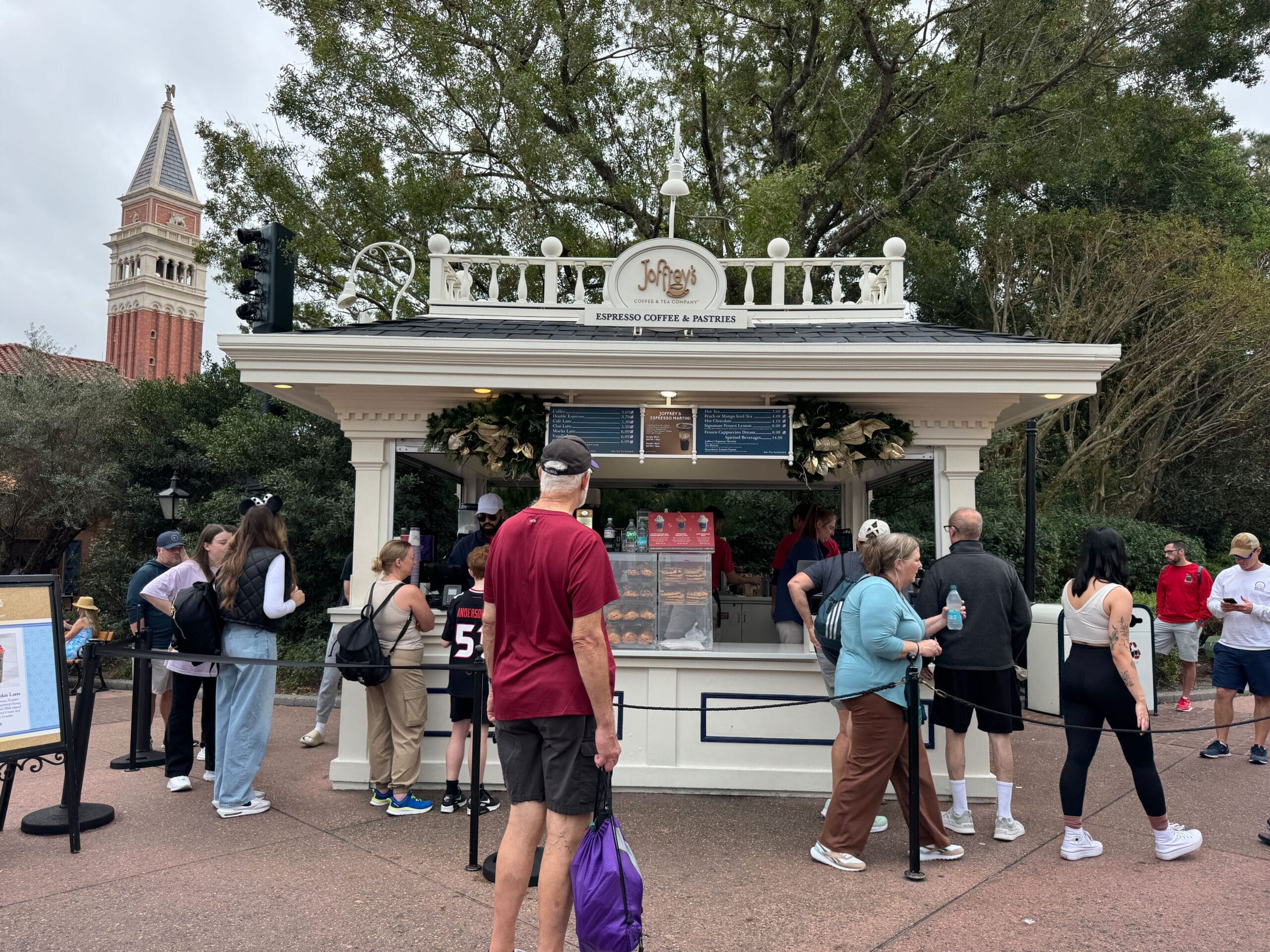 People eagerly gather at Joffrey's coffee and pastry kiosk, nestled in the serene park setting.