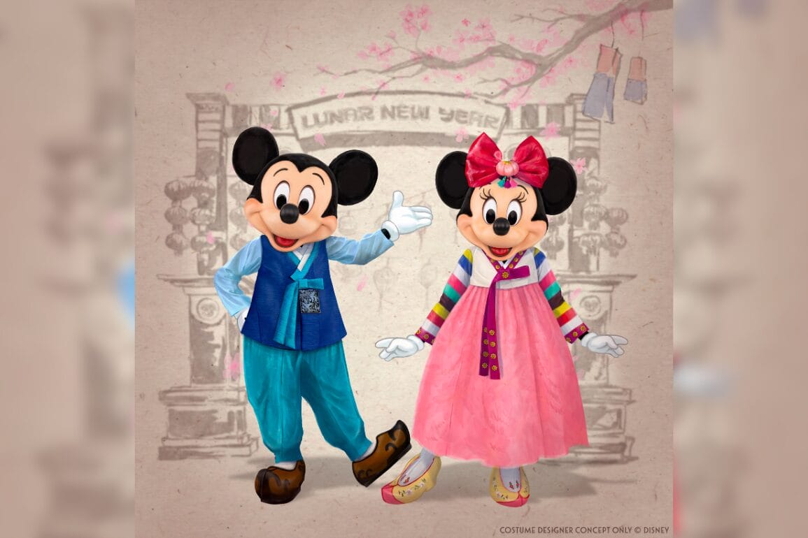Mickey and Minnie Mouse in festive outfits standing in front of a Lunar New Year-themed backdrop.