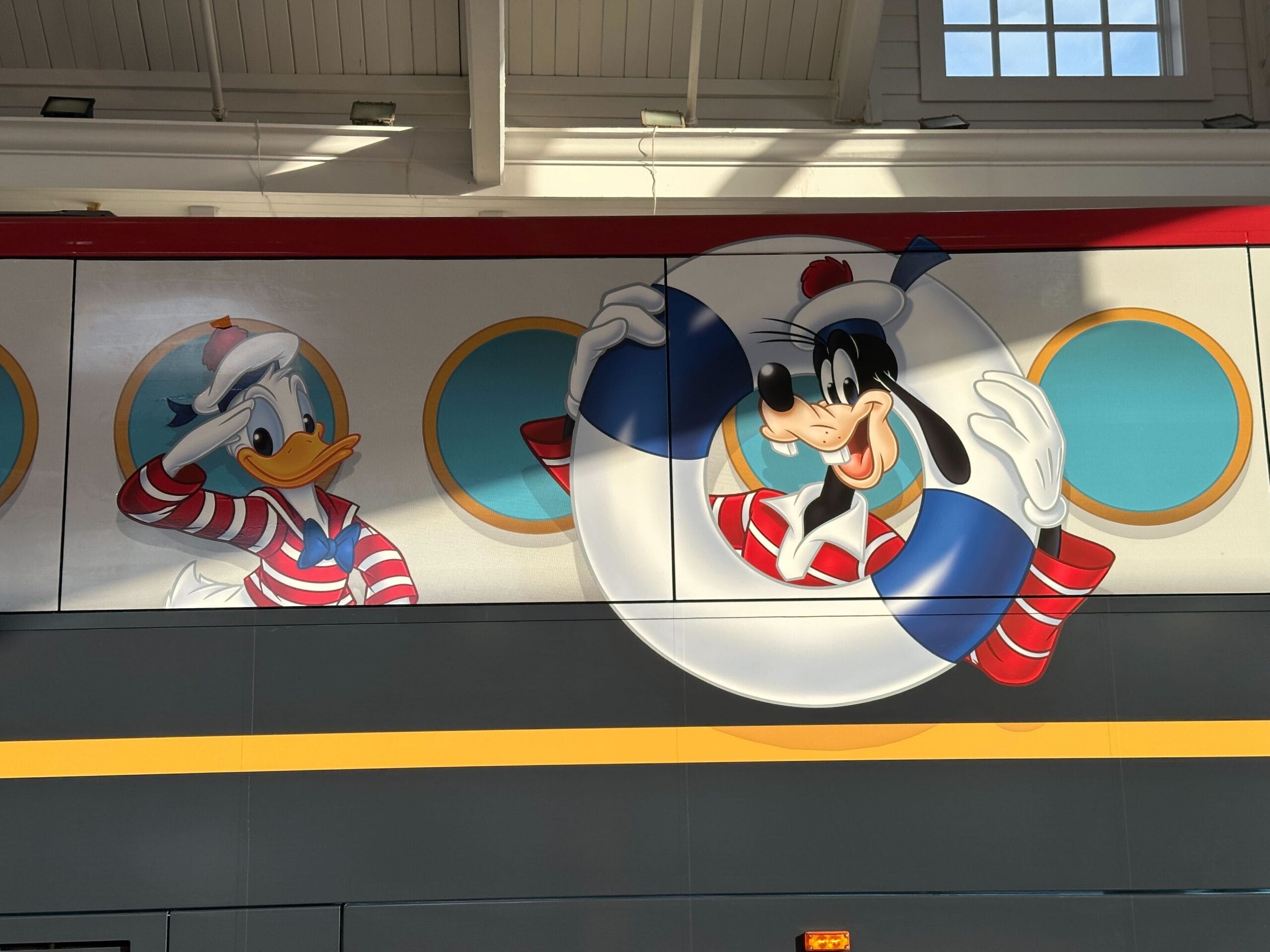 Cartoon characters appear in sailor outfits on a vehicle, one holding a life preserver.