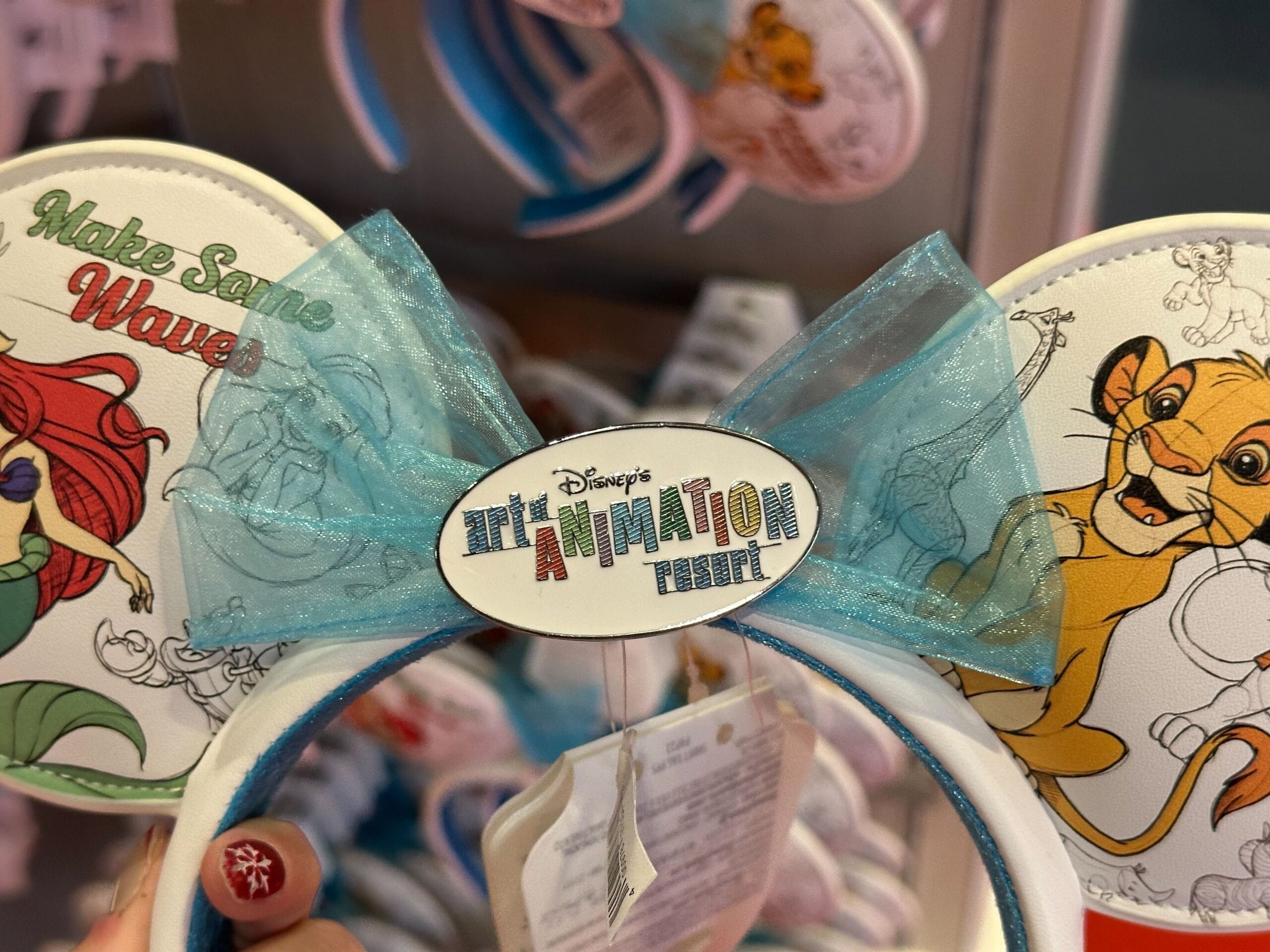 Close-up of Disney's Animation Tribute-themed ears featuring Ariel and Simba with a blue bow in the center.