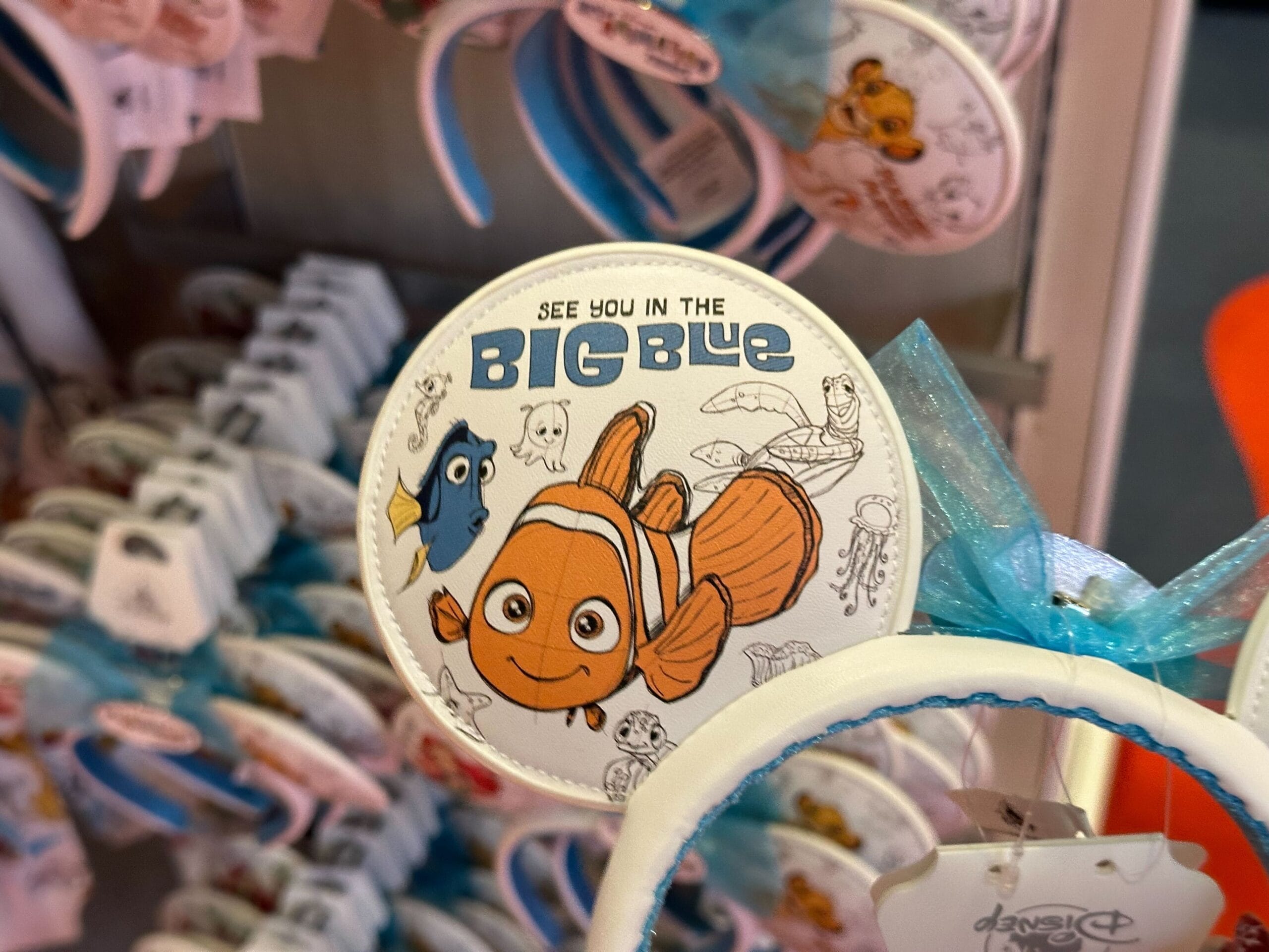 A display of headbands featuring characters from "Finding Nemo," with Dory and Nemo on the tag and the phrase "See you in the Big Blue.