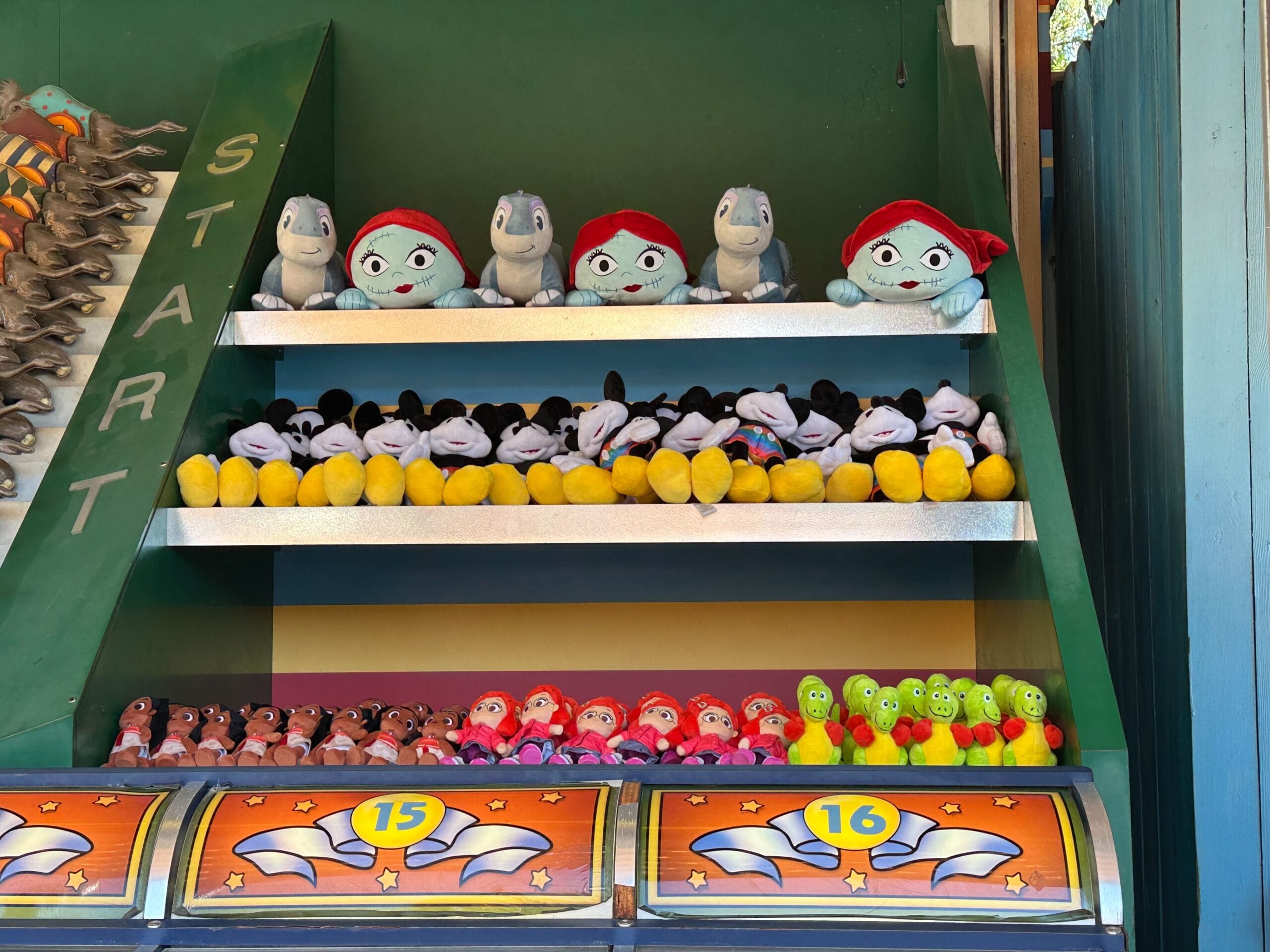 A carnival game display featuring shelves of plush Wishables, including cartoon characters and animals, with numbered slots below indicating prize tiers. Reminiscent of DinoLand Carnival Games, it's a whimsical closure to a fun-filled day.