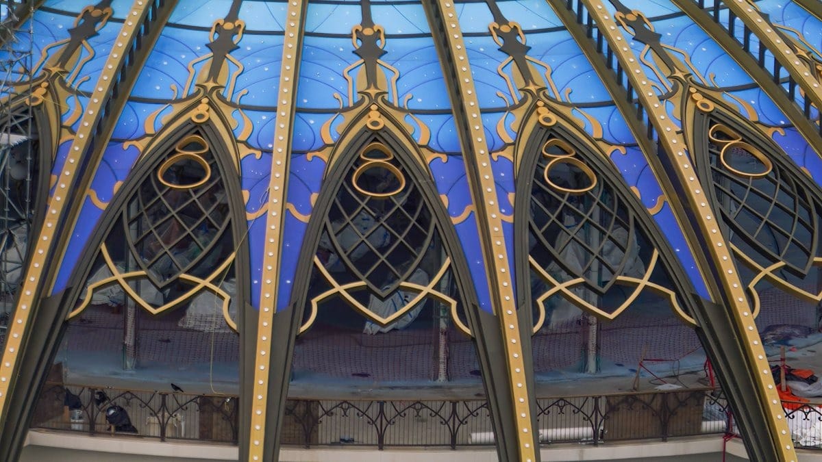 A dome with intricate golden frames and blue stained glass panels featuring geometric patterns evokes the grandeur of an epic universe.