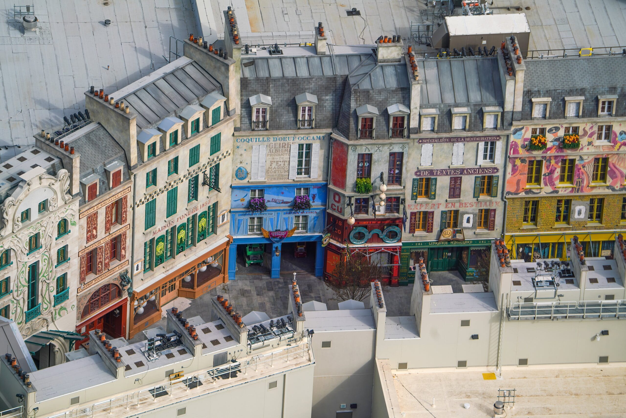 From the rooftop, catch a breathtaking view of colorful, detailed building facades lining the small alleyway below, reminiscent of an enchanting theme park adventure. The scene almost transports you to an epic universe far from the bustling heart of Orlando, all beneath the sprawling gray roof.