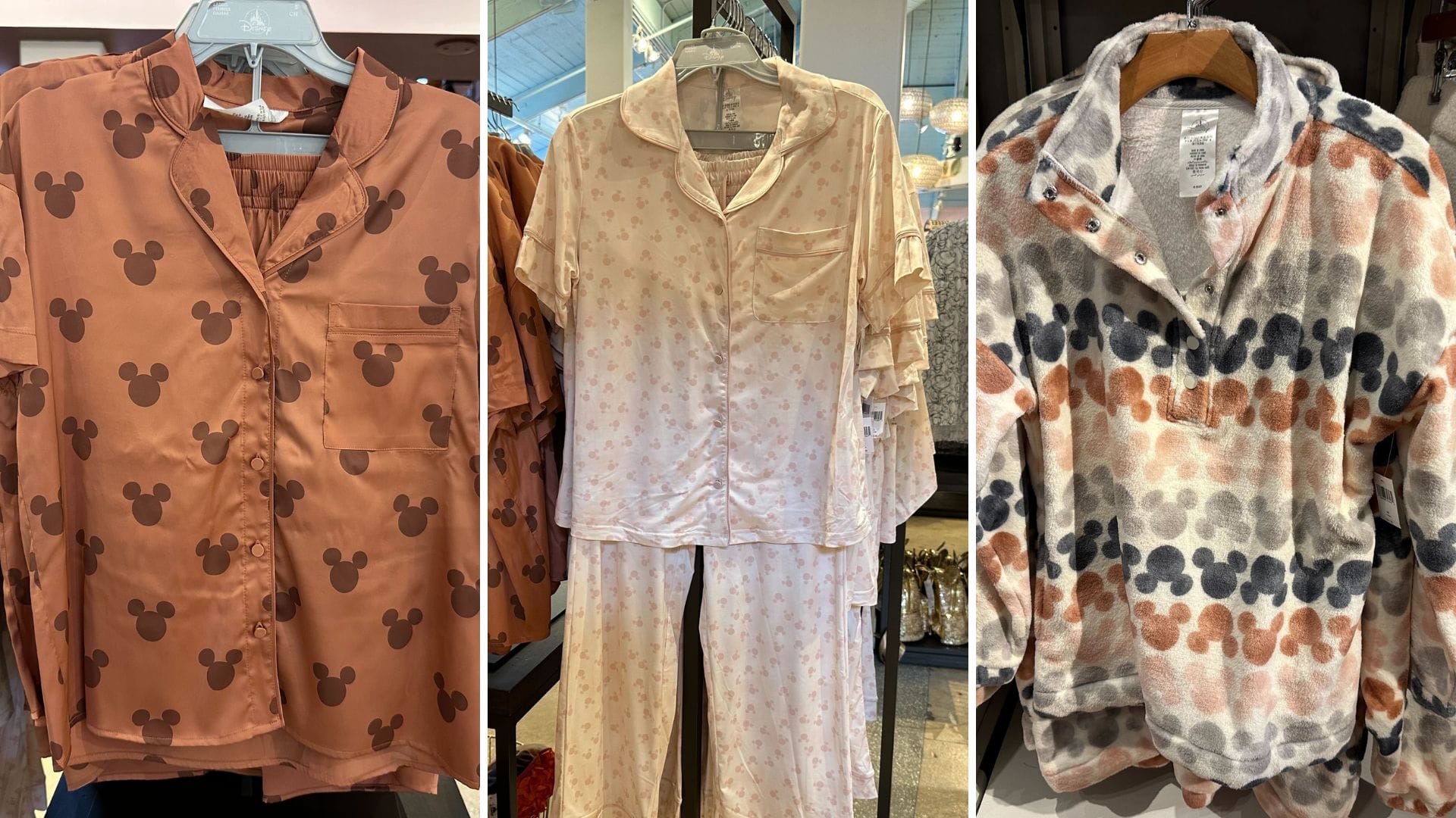 Three sets of clothing on hangers: a brown pajama with character motifs, a light pink satin pajama with subtle patterns, and a fleece jacket with multicolored spots.