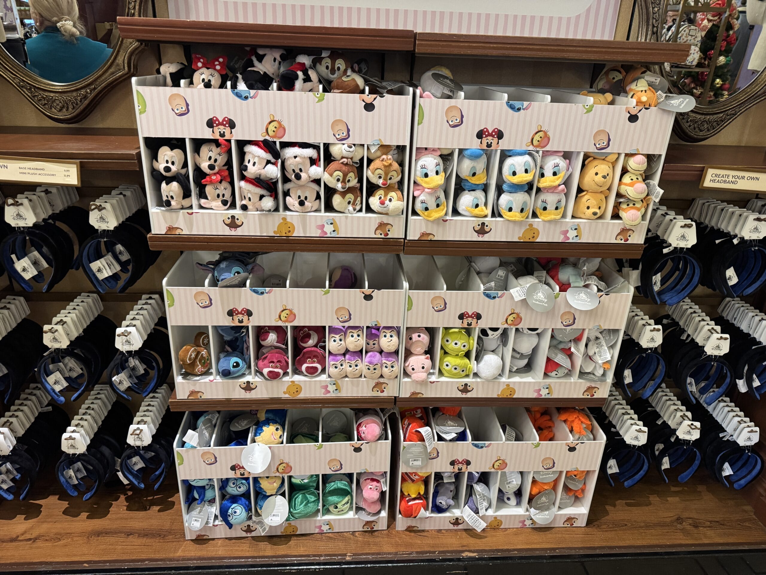 A vibrant photo report from 2024 showcases an enchanting display of plush toys at Magic Kingdom, neatly arranged in organized bins on shelves, featuring characters in a delightful array of colors.
