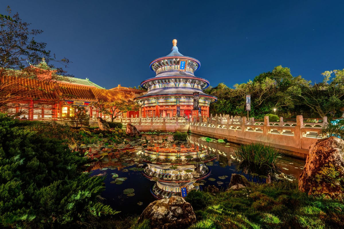 Colorful China pavilion at Epcot, its pagoda-style glow reflected in a pond, inspired by Reflections of China.