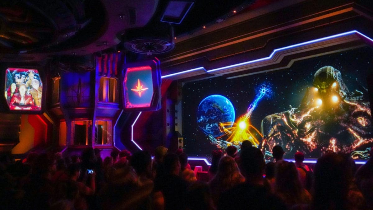 Crowd watches a cosmic-themed show with space visuals and a giant alien on a stage inspired by Guardians of the Galaxy.