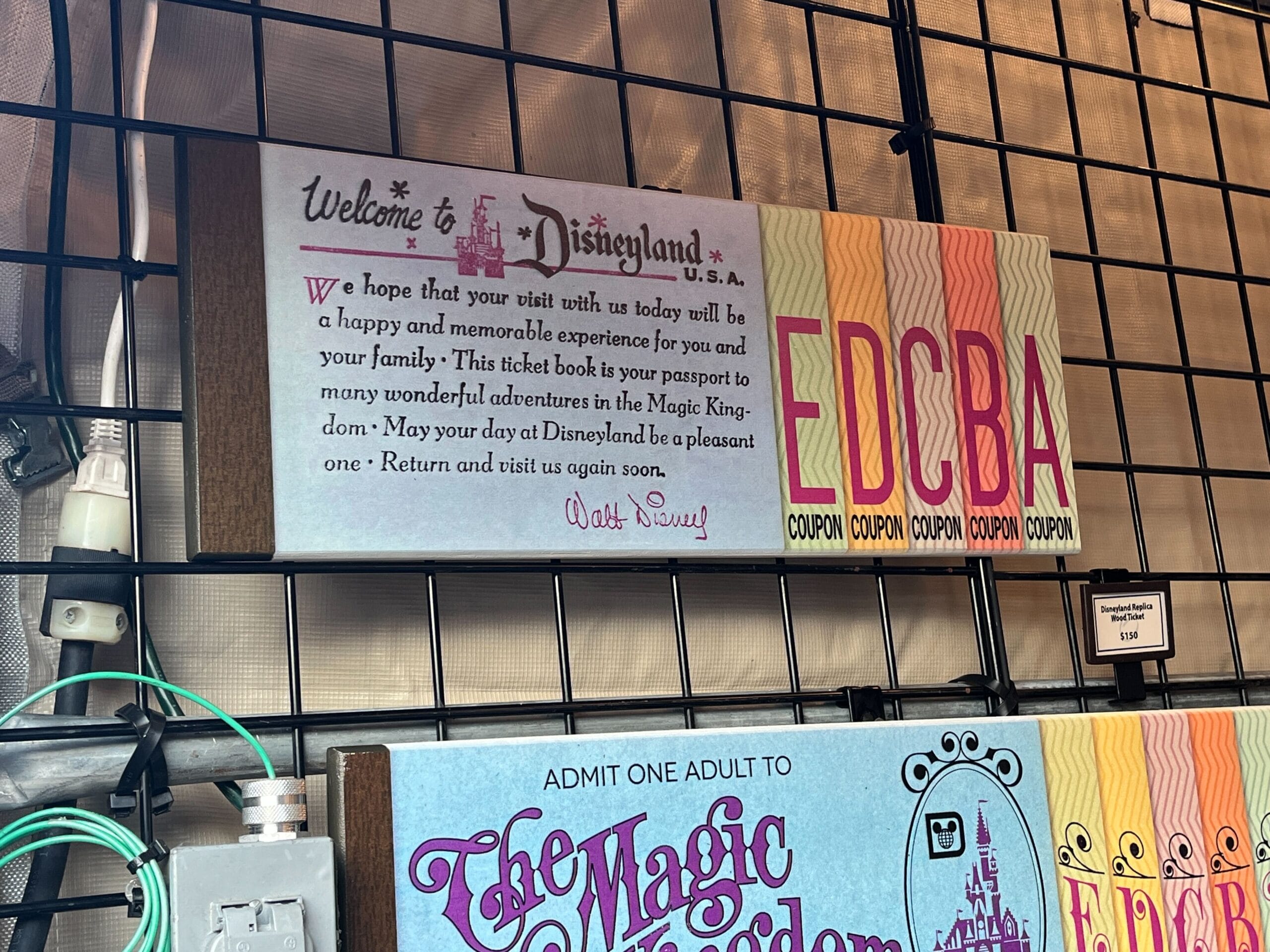 Explore a vintage Disneyland ticket display featuring colored coupon letters EDCBA and a warm welcome message, reminiscent of Dave Avazano's artistic flair at the Festival of the Arts.