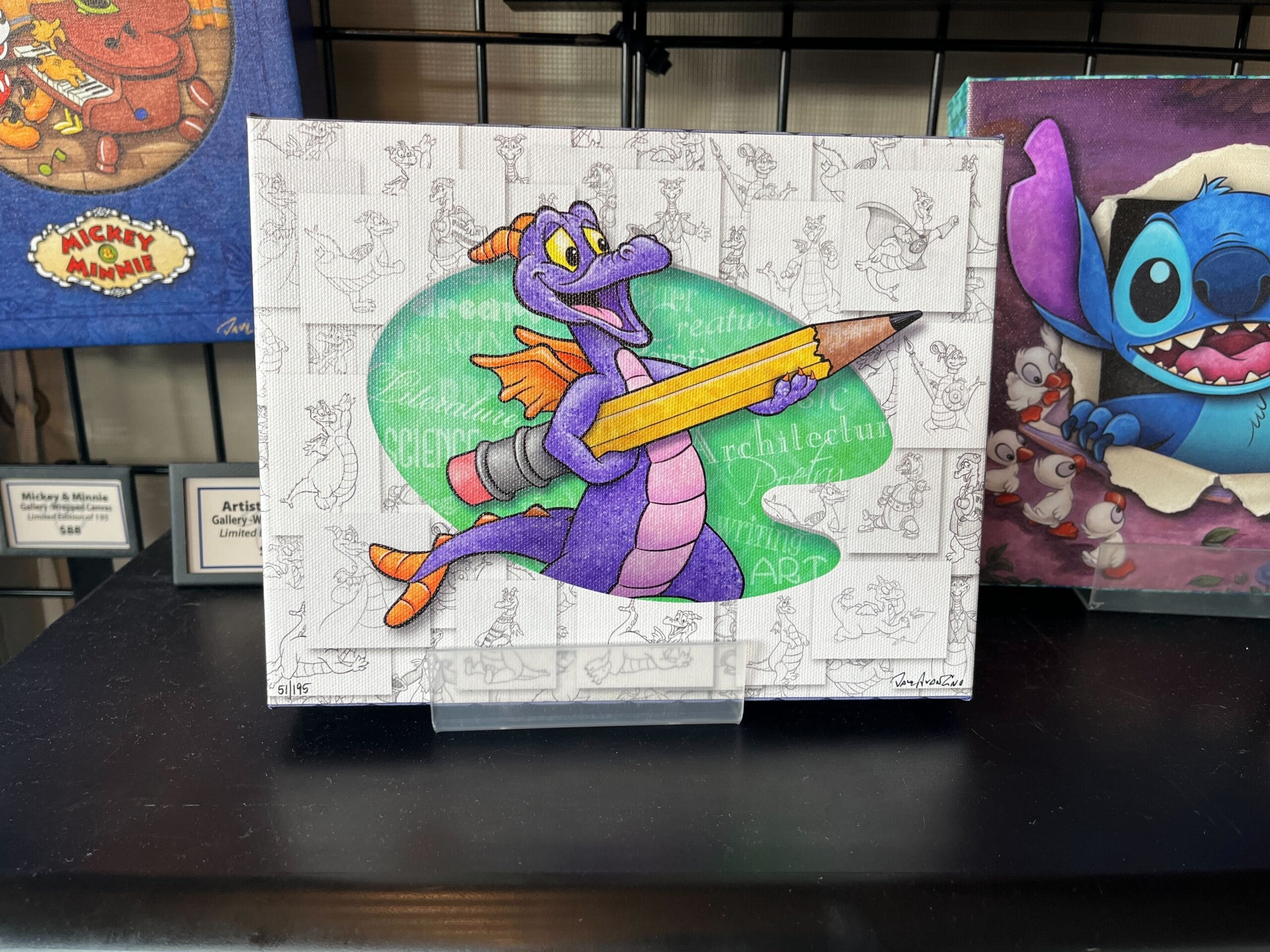 A vibrant illustration of a purple dragon holding a pencil, set against a backdrop of sketches. Featured at the EPCOT Festival of the Arts 2025, this piece is surrounded by other artwork, including Dave Avazano’s "Mickey's Munny" creation.