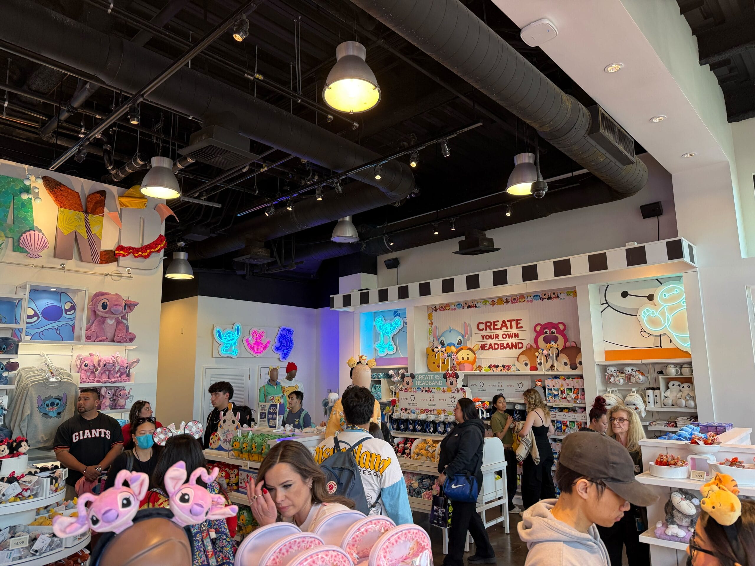 People browsing merchandise in a brightly lit store filled with colorful cartoon-themed items and decorations.