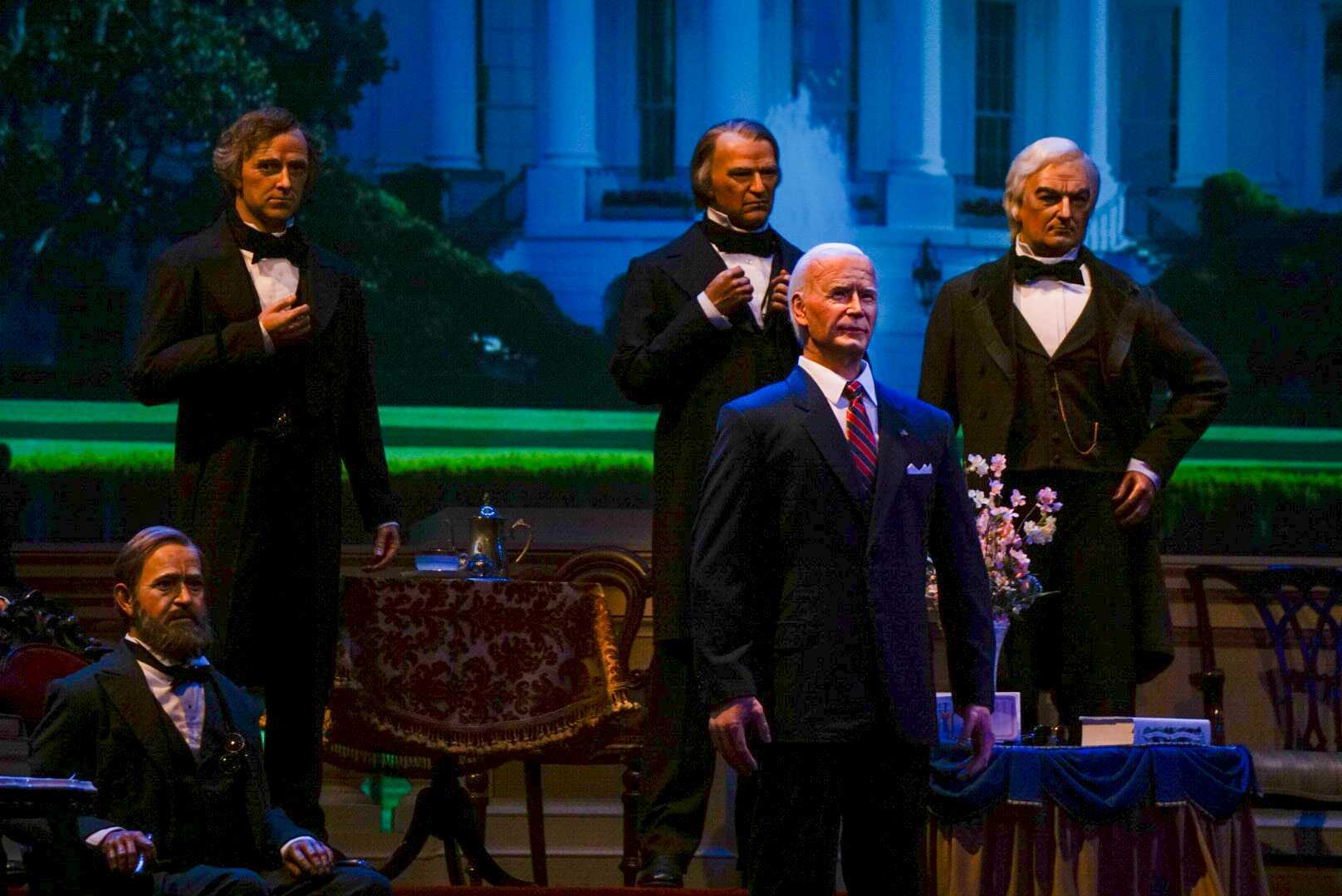 Animatronic figures of U.S. presidents stand in formal attire at Disney World's Hall of Presidents attraction.