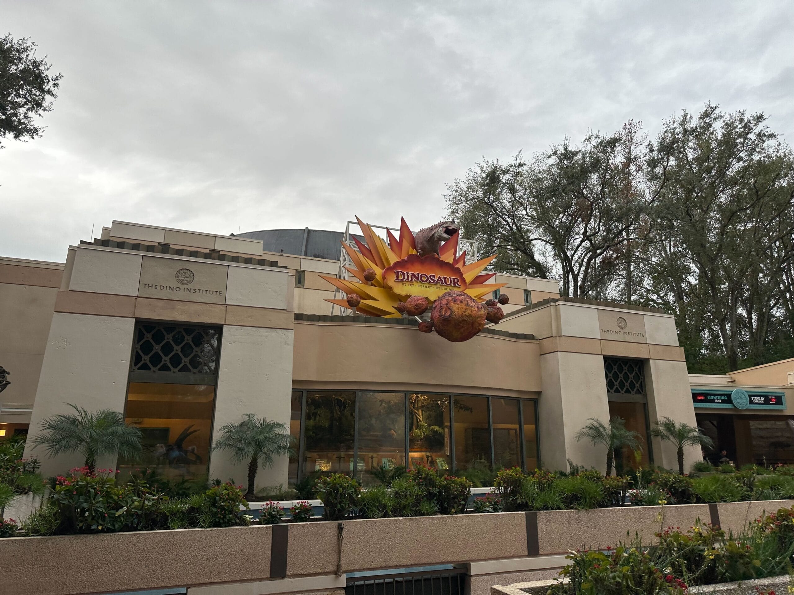 The exterior of the building features a vibrant "DINOSAUR" sign, showcasing a dinosaur against a burst of flames, perfectly capturing the adventurous spirit of Dinoland.