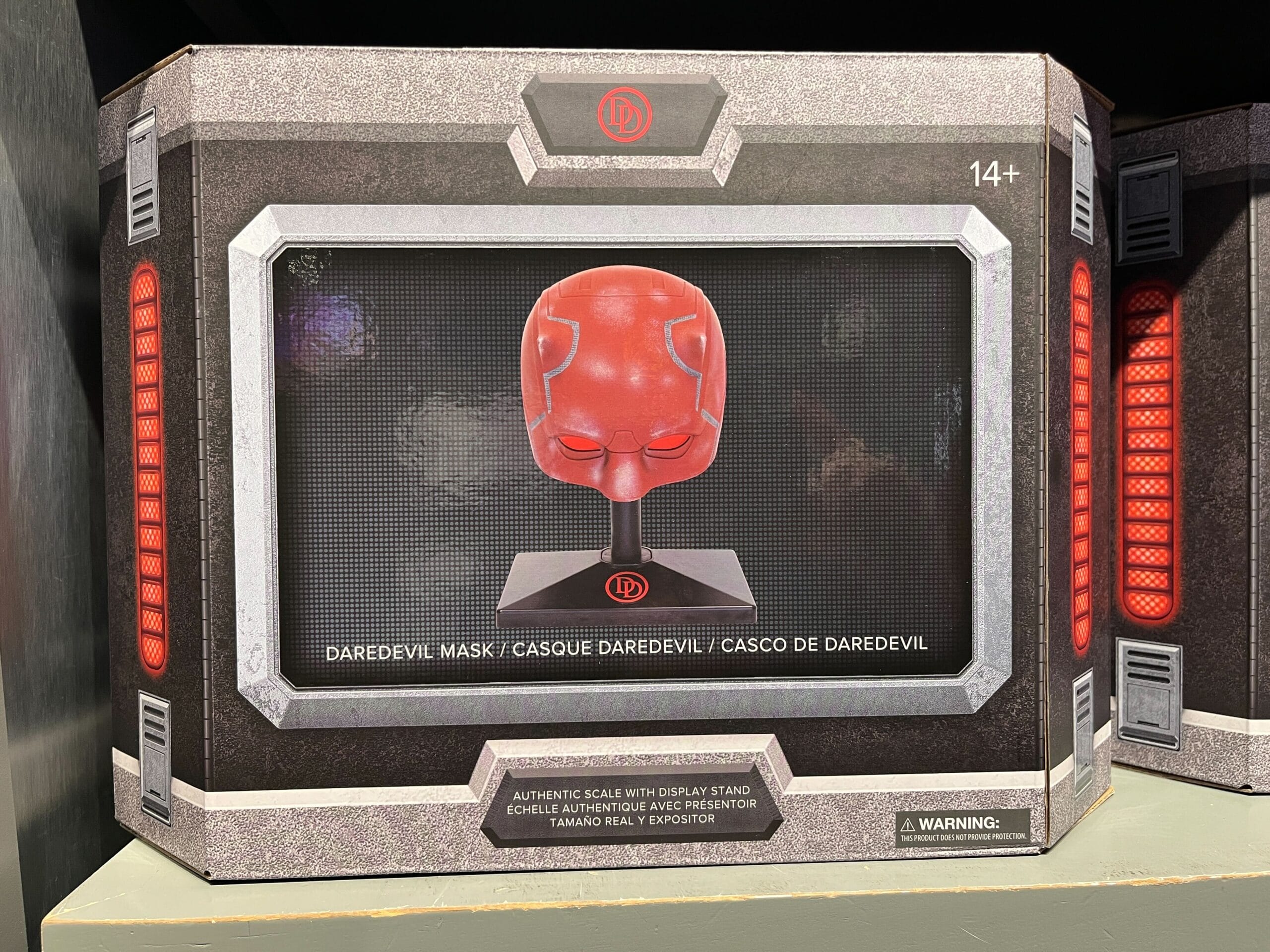 Box containing a red Daredevil mask with a display stand, labeled for ages 14 and up, featuring instructions in multiple languages.