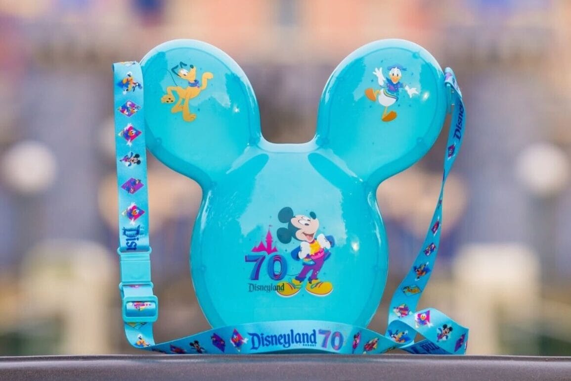 A blue balloon-shaped souvenir, featuring Mickey Mouse and Donald Duck designs, commemorates Disneyland's 70th anniversary. This light-up Mickey balloon, doubling as a popcorn bucket, comes with a Disneyland 70 strap attached.