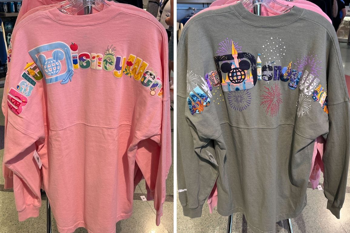 Two long-sleeve shirts on hangers showcase colorful "Disney World" designs with various decorative icons. One is a pink Walt Disney World Spirit Jersey, and the other is a gray one.