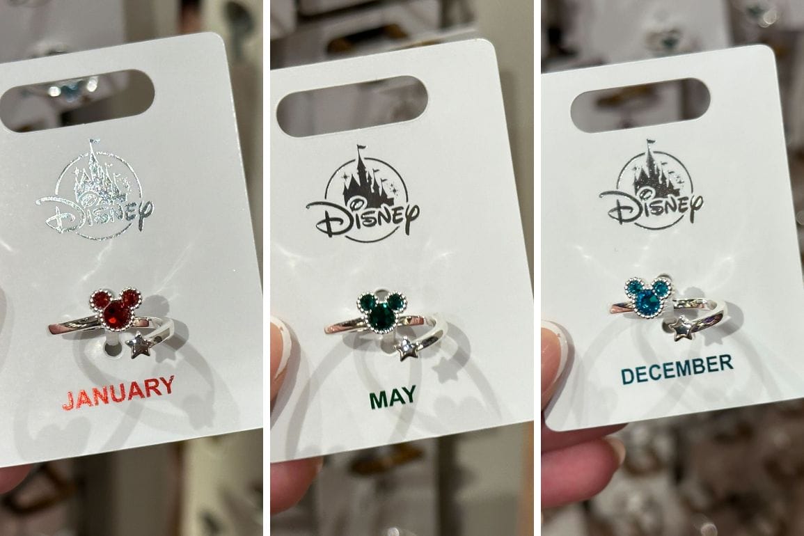 Three New Mickey Birthstone Rings, each adorned with a jeweled Mickey Mouse shape and a star charm, sparkle on cards labeled January, May, and December.