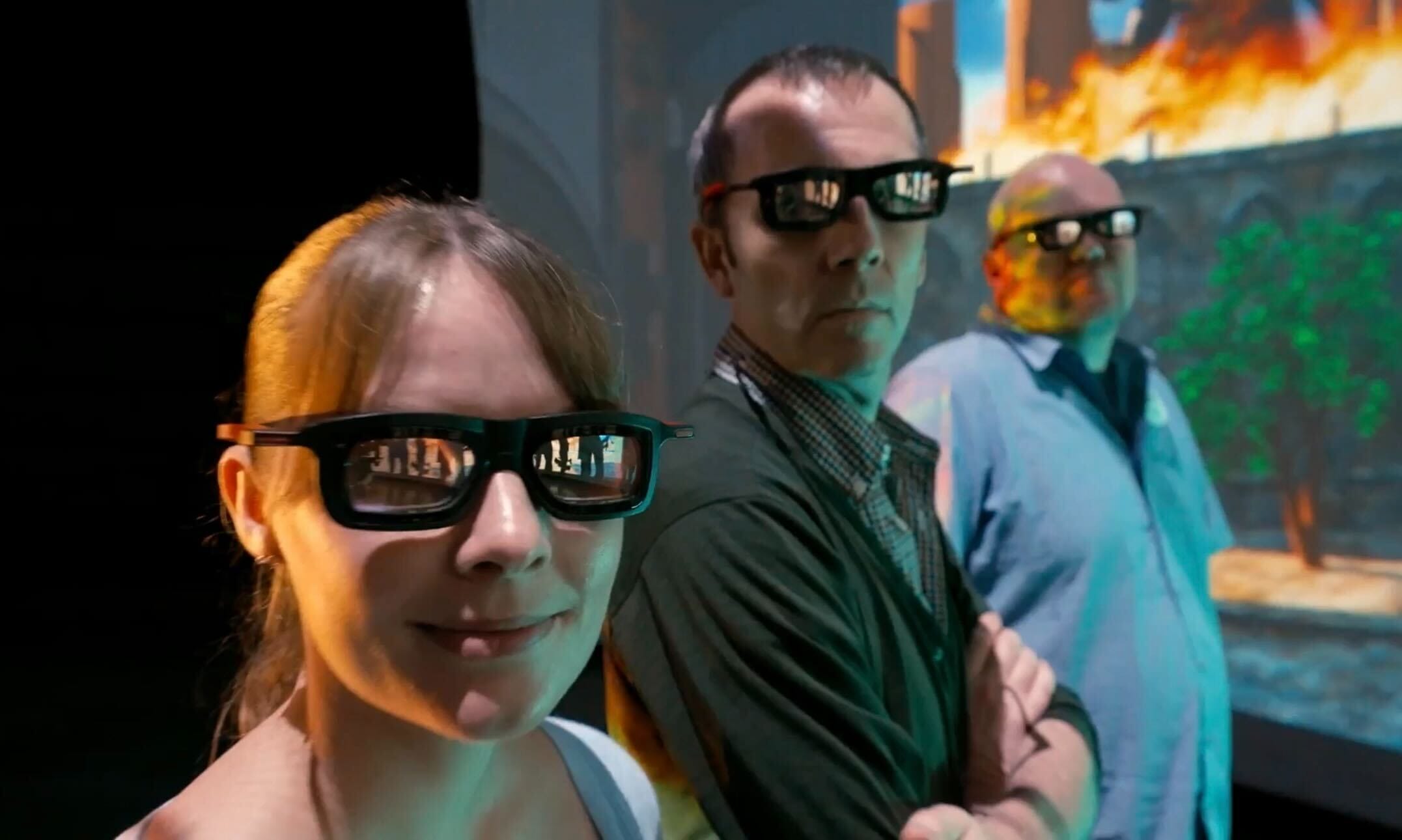 Three people wearing 3D glasses stand in a row, facing the camera. They appear to be in a multiverse-jumping adventure, as if stepping right out of an Avengers: Infinity Defense scenario with their immersive environment setting the stage for endless possibilities.