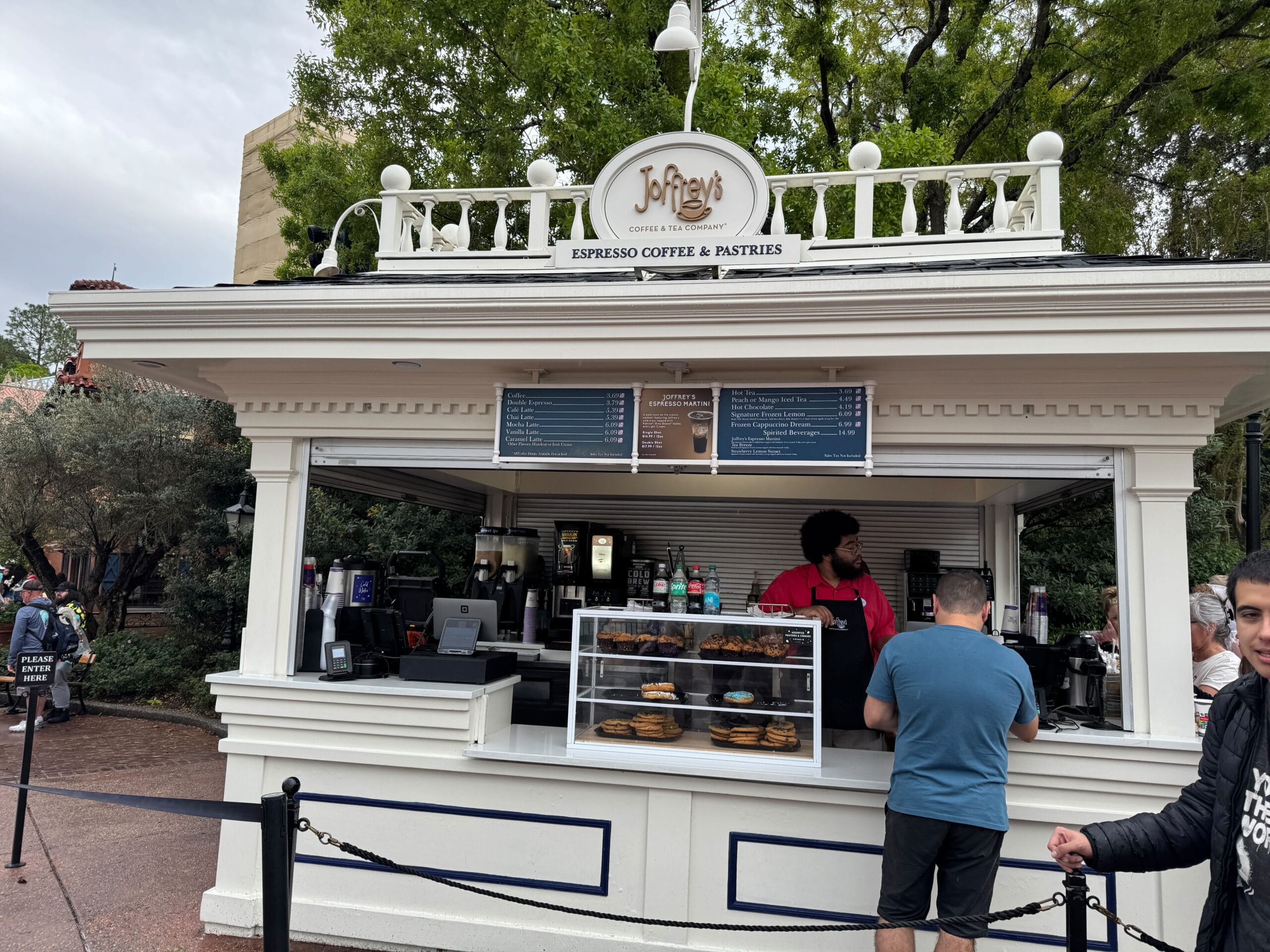Joffrey's outdoor coffee and pastry kiosk features two friendly baristas ready to serve you delightful treats, all under a charming overhead menu.
