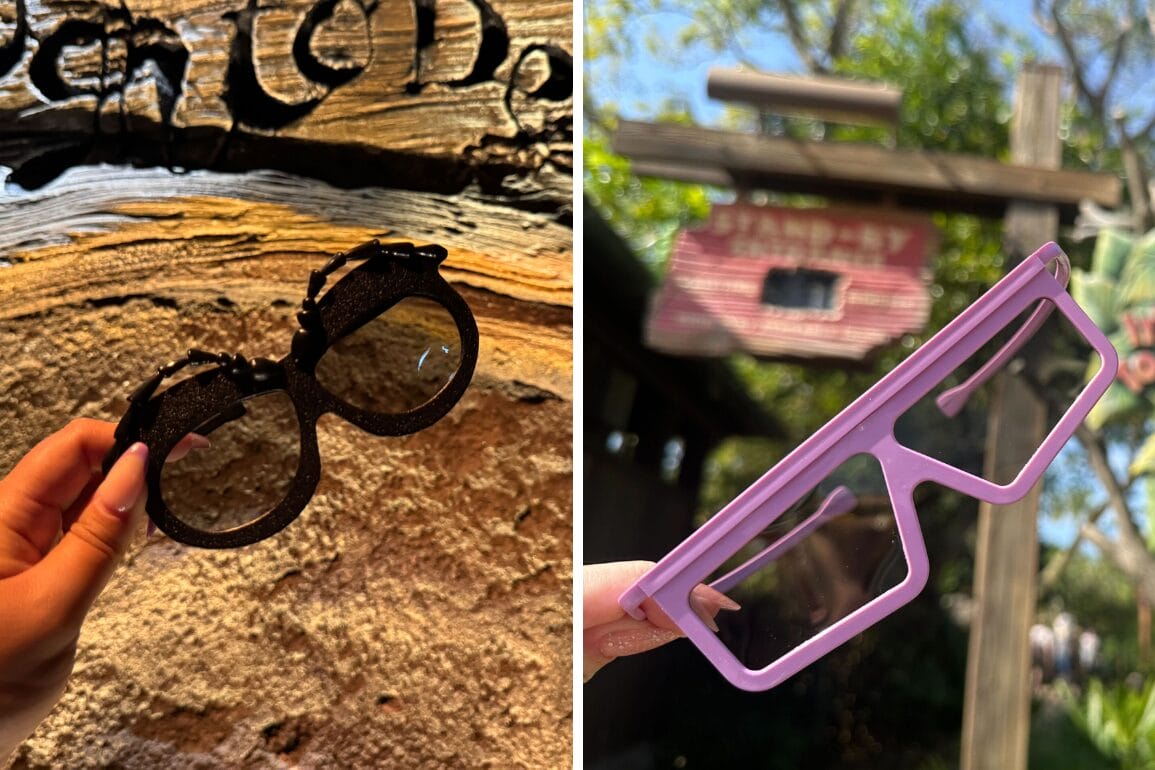 A hand holds a pair of black MuppetVision 3D glasses on the left against a wooden background, while another hand holds pink 3D glasses on the right with trees and a red sign in the background.