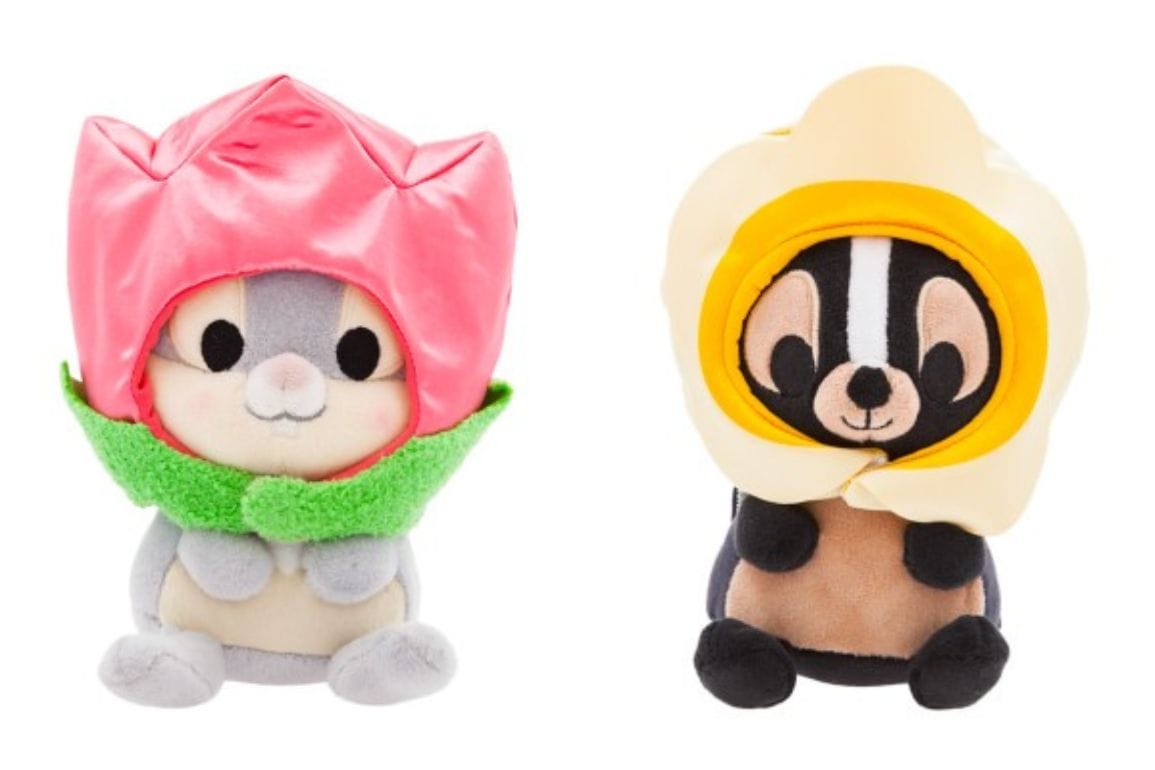 Two plush toys from the Disney Store: a gray animal with a pink flower hat and green collar on the left, reminiscent of Thumper, and a brown animal on the right with a yellow flower hat, both sitting upright.