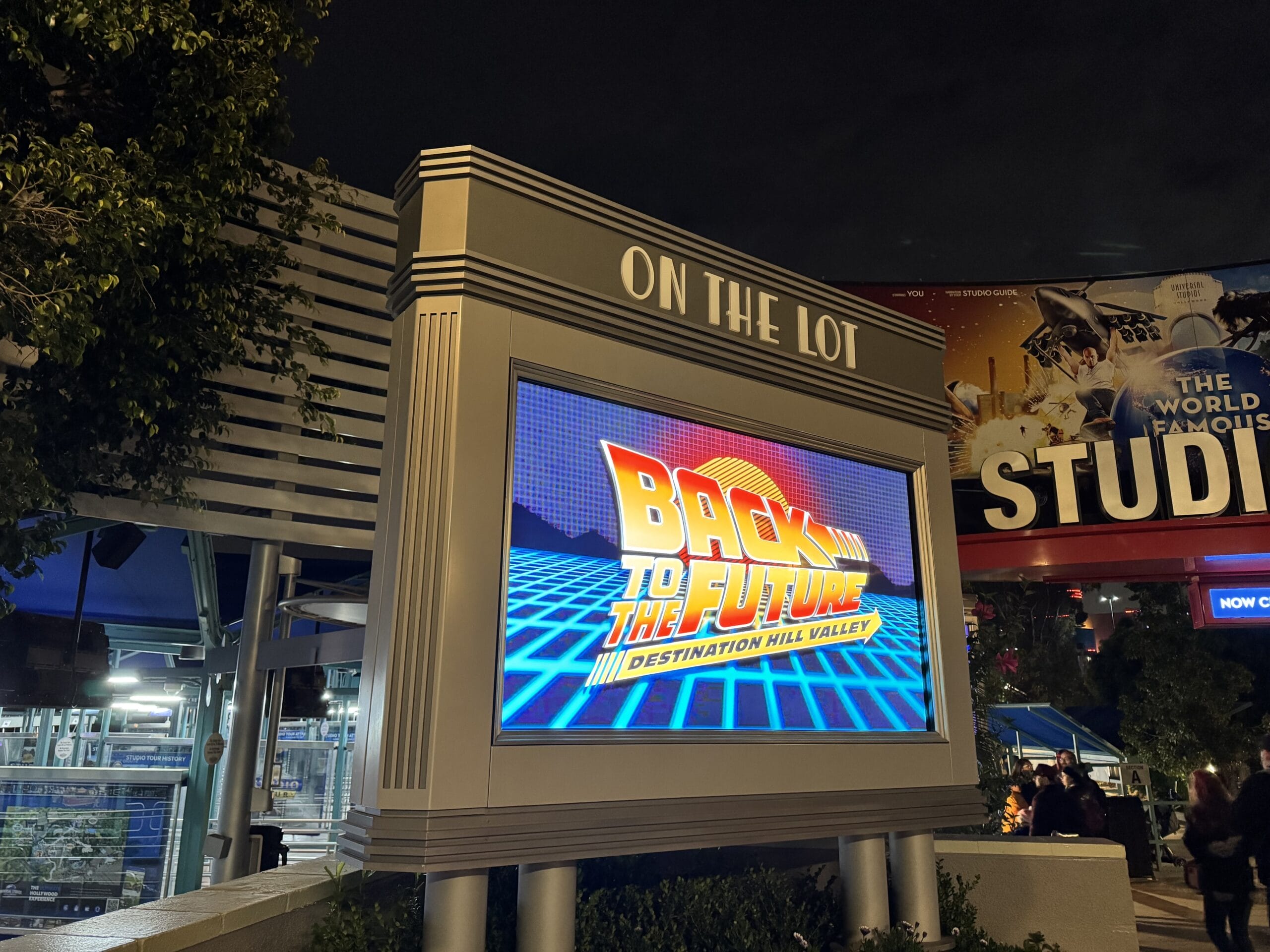 A digital sign displays "Back to the Future: Destination Hill Valley" during Universal Fan Fest Nights at a studio lot entrance.