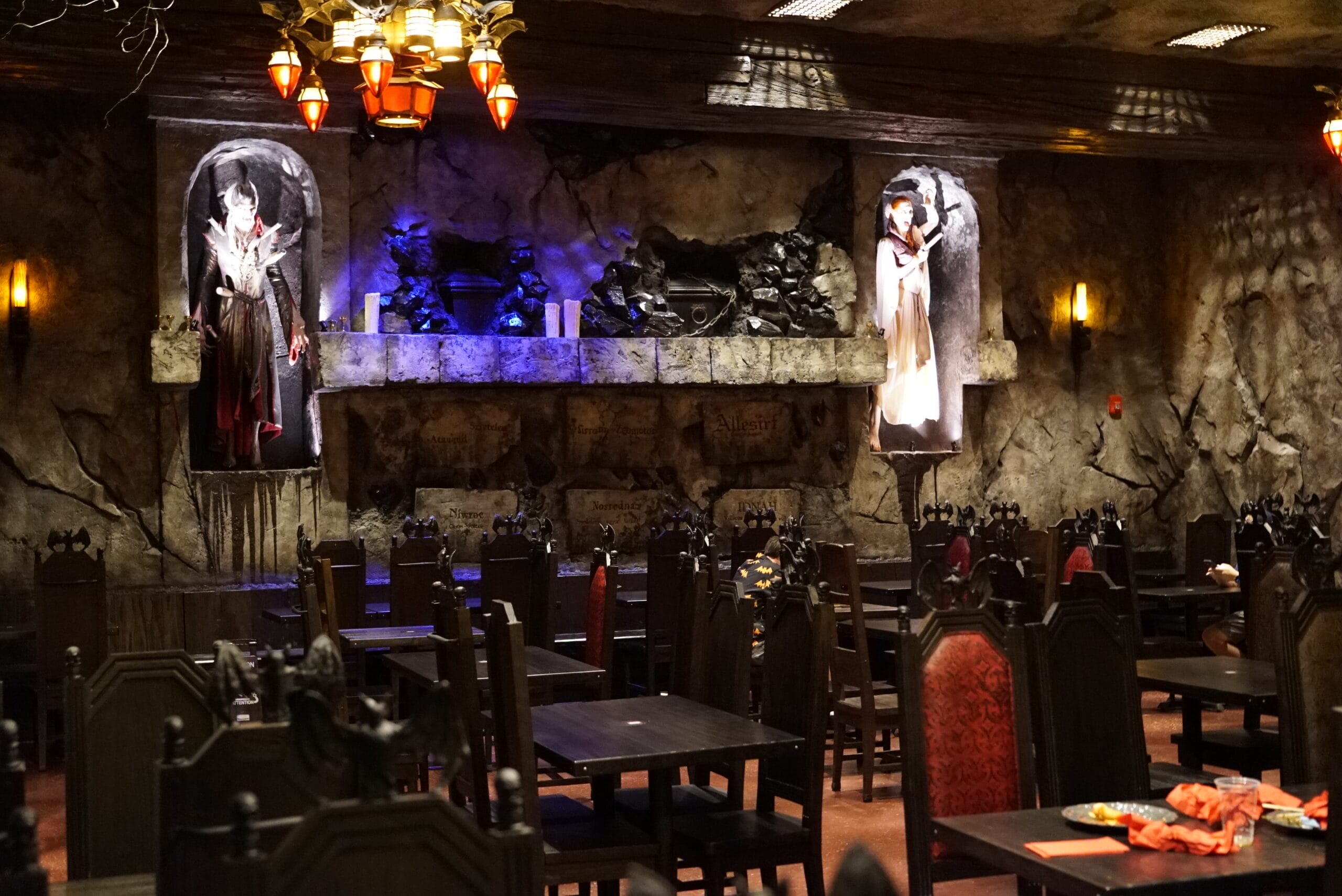 Das Stakehaus is a gothic-themed restaurant with dark decor, chandeliers, and statues in alcoves on stone walls.