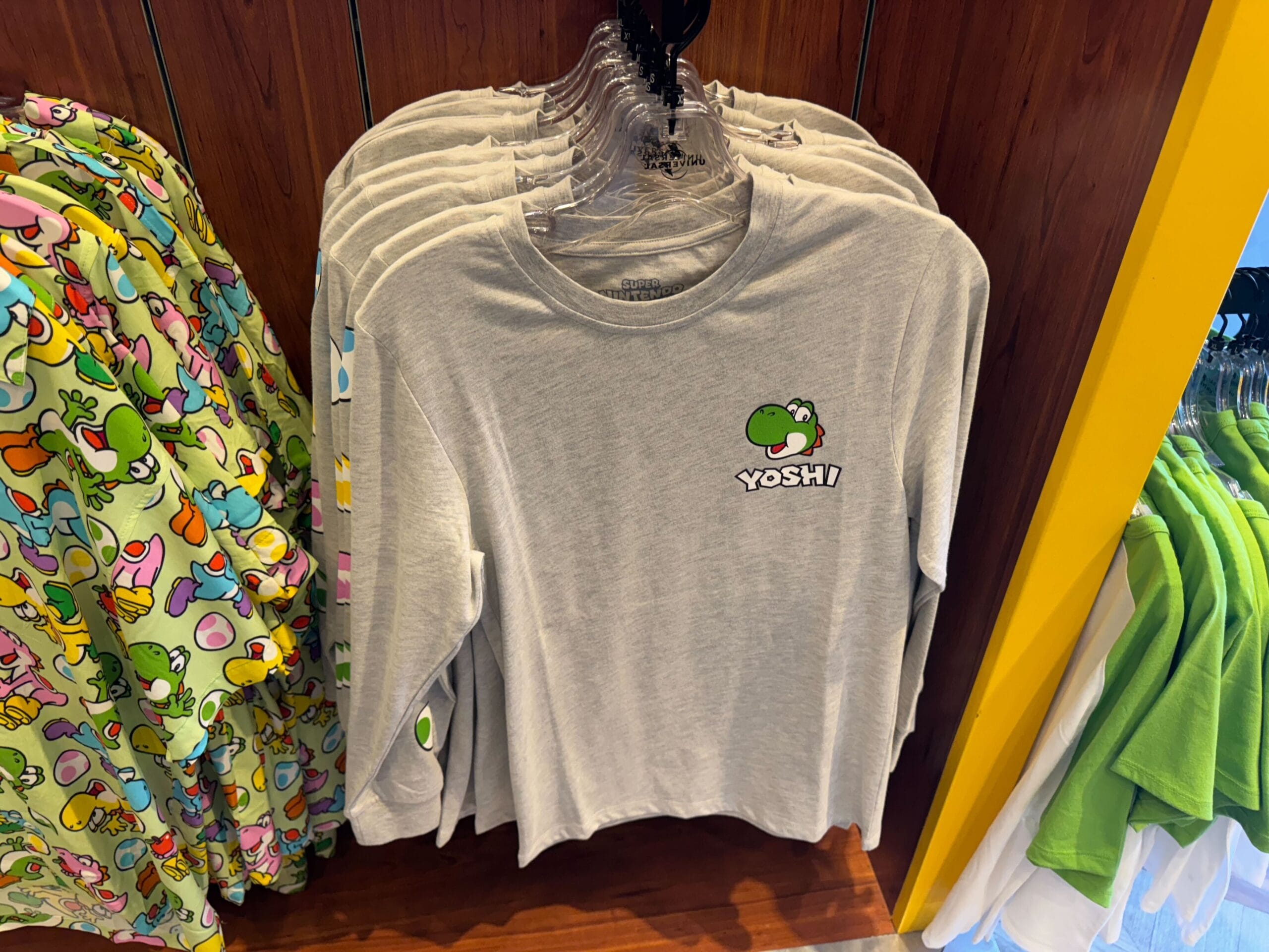 Gray long-sleeve Yoshi shirts, official Yoshi merchandise, displayed in-store at Universal Studios Hollywood.