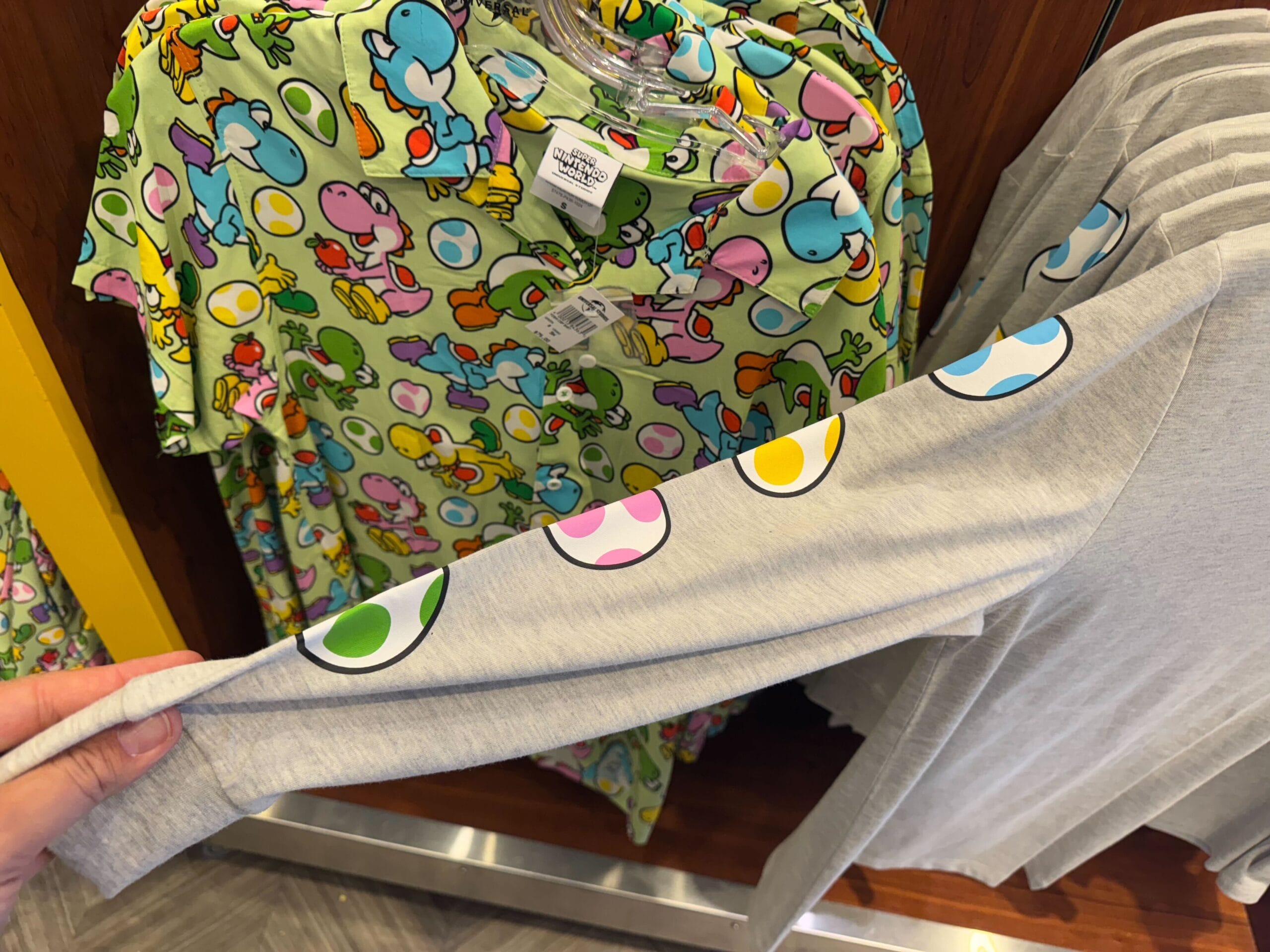 Yoshi merchandise, including egg-print shirts and a sleeve, is displayed at Universal Studios Hollywood.