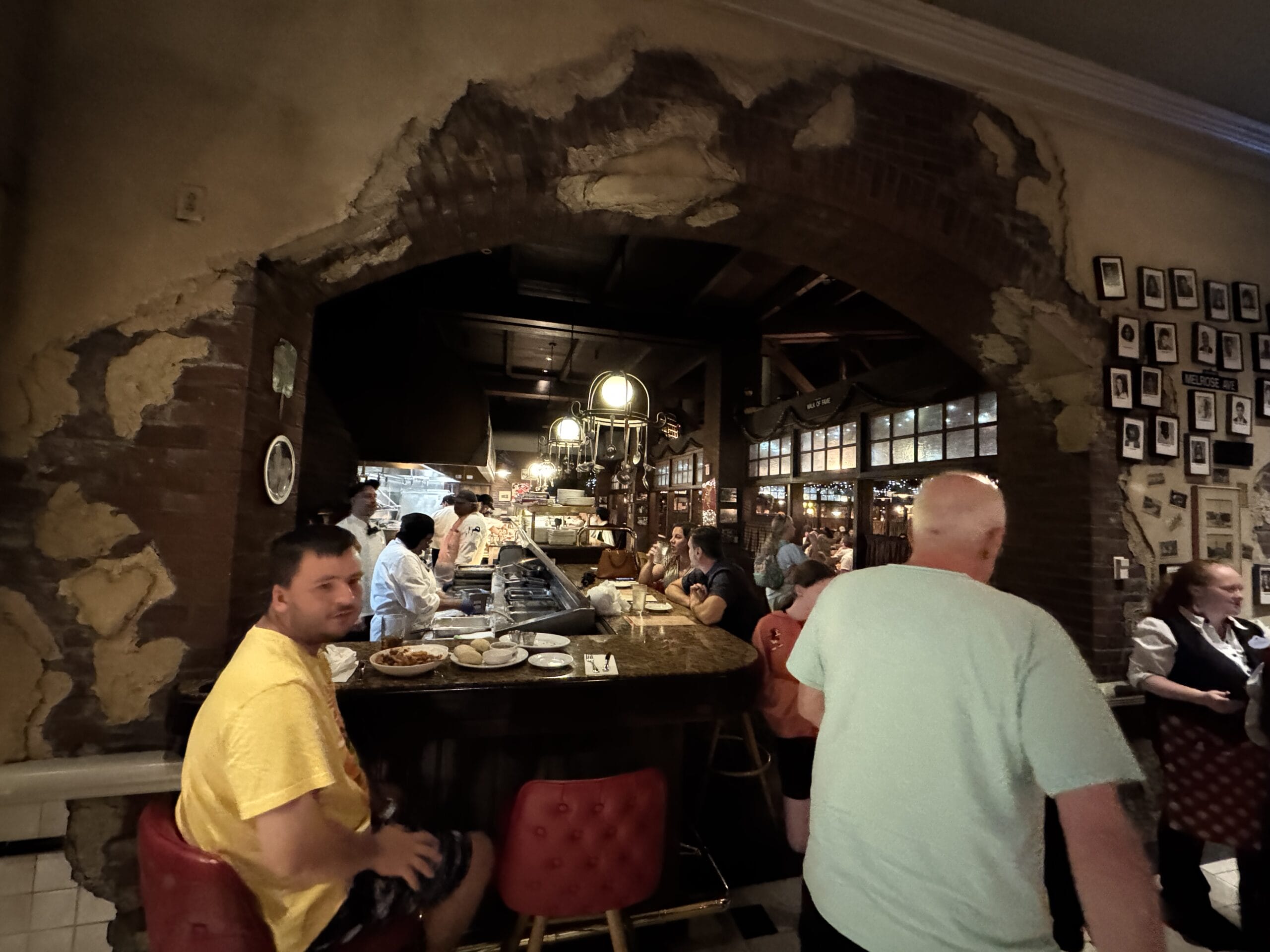 People dining and chatting at Mama Melrose’s Ristorante Italiano, a rustic spot in Disney's Hollywood Studios—perfect for photos.