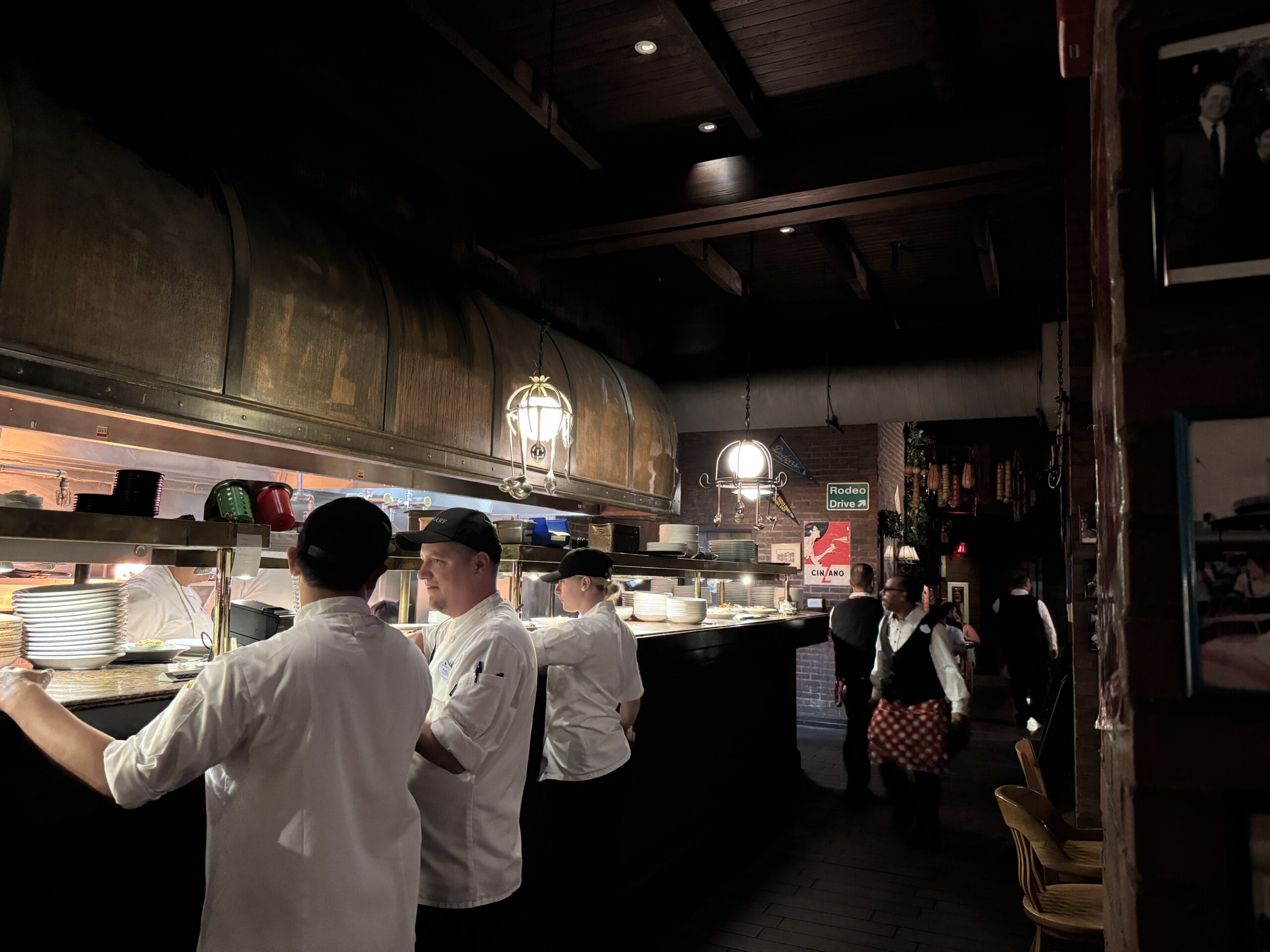 Chefs cook at Mama Melrose’s Ristorante Italiano in dim lighting, as seen in photos from Disney's Hollywood Studios.